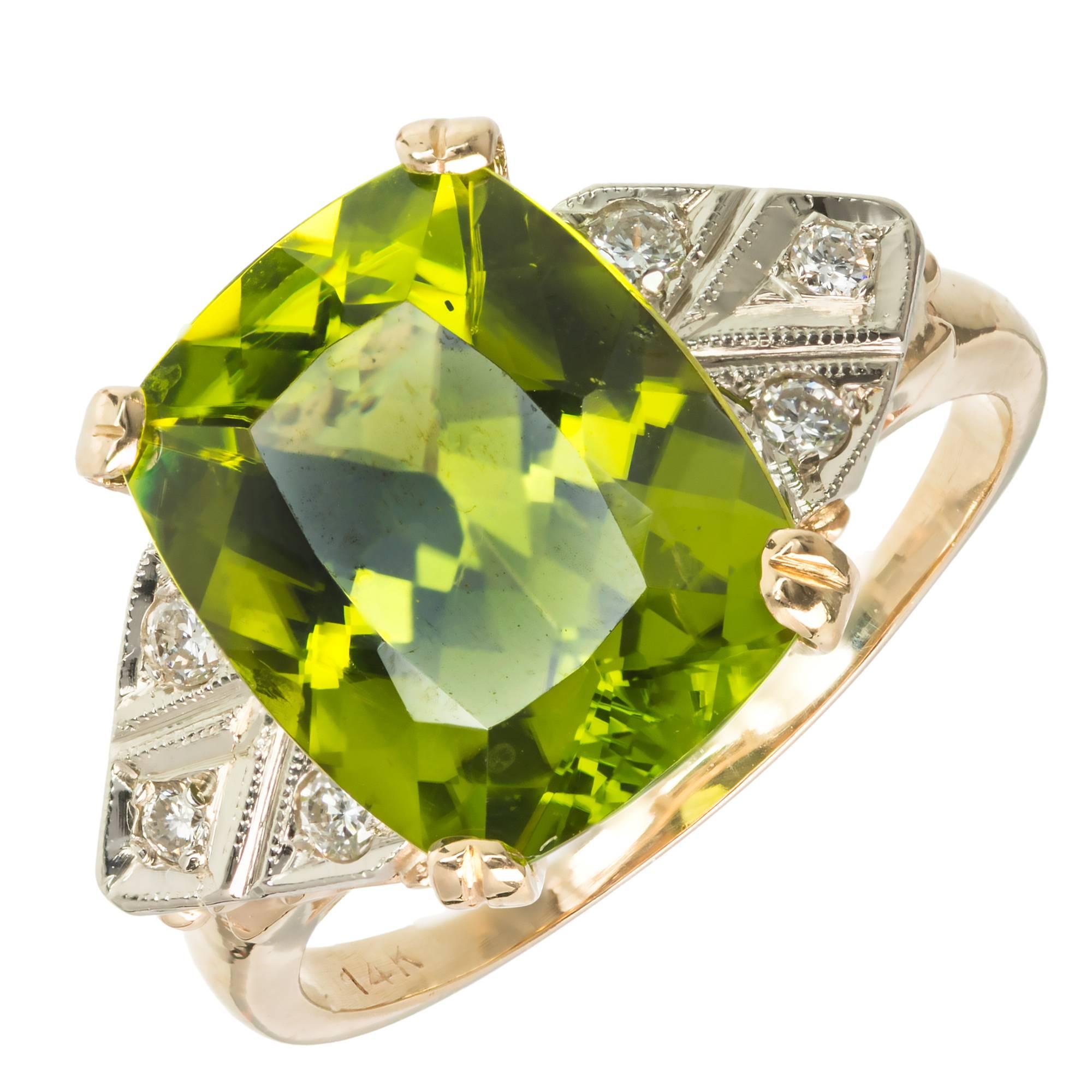 1940 14k yellow gold ring with a bright green Peridot and full cut Diamond accents in 14k white gold.

1 cushion green Peridot, approx. total weight 6.50cts, SI1
6 round full cut Diamonds, approx. total weight .16cts, H, SI1
14k white gold
Tested