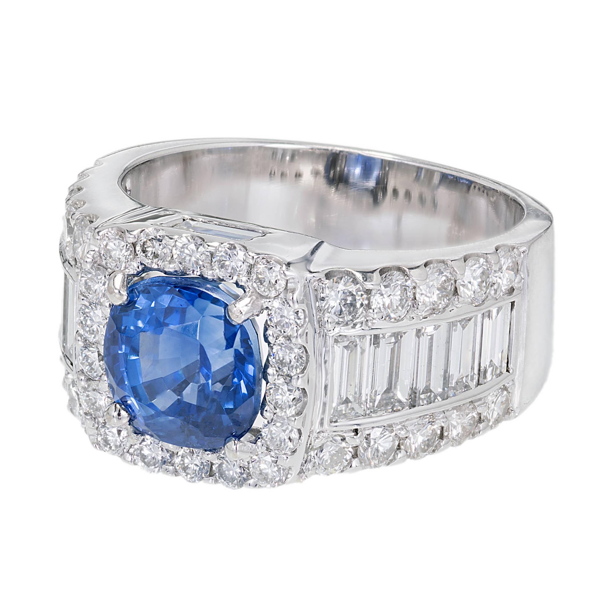Bright cornflower blue cushion Sapphire engagement ring. In a custom made setting with a cushion shape top and wide sides set with bright shiny colorless Diamonds.

1 round bright cornflower blue Sapphire, approx. total weight 3.07cts, VS, GIA