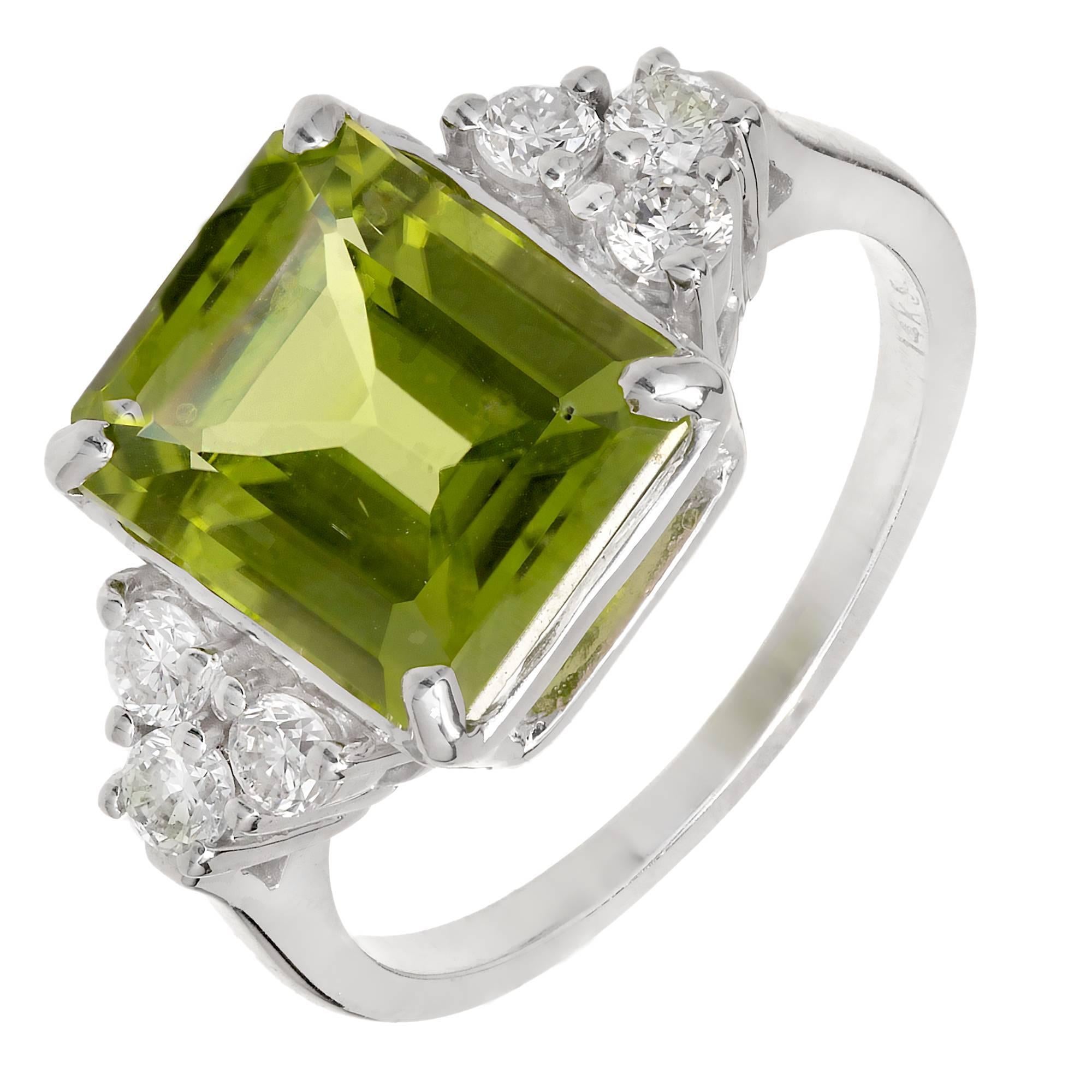 Emerald cut 3.93ct Peridot engagement ring with a very bright green Peridot and bright sparkly Diamonds in a 14k white gold setting.

1 Emerald cut medium bright green Peridot, approx. total weight 3.93cts, VS
6 round full cut Diamonds, approx.