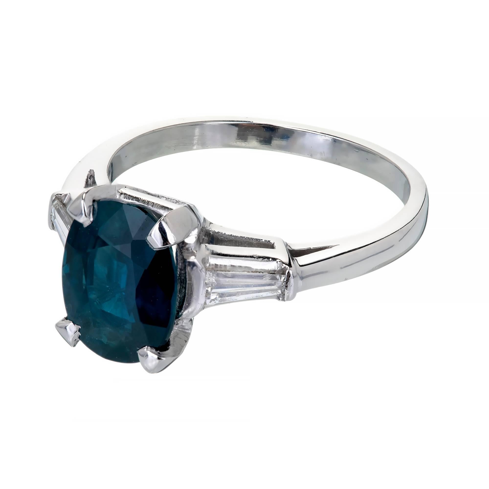 Vintage 1950 three-stone Platinum engagement ring with a deep blue 3.01ct GIA certified natural no heat oval Sapphire and tapered baguette Diamond accents.

1 oval blue Sapphire, approx. total weight 3.01cts, MI, natural no heat, 9.63 x 7.32 x