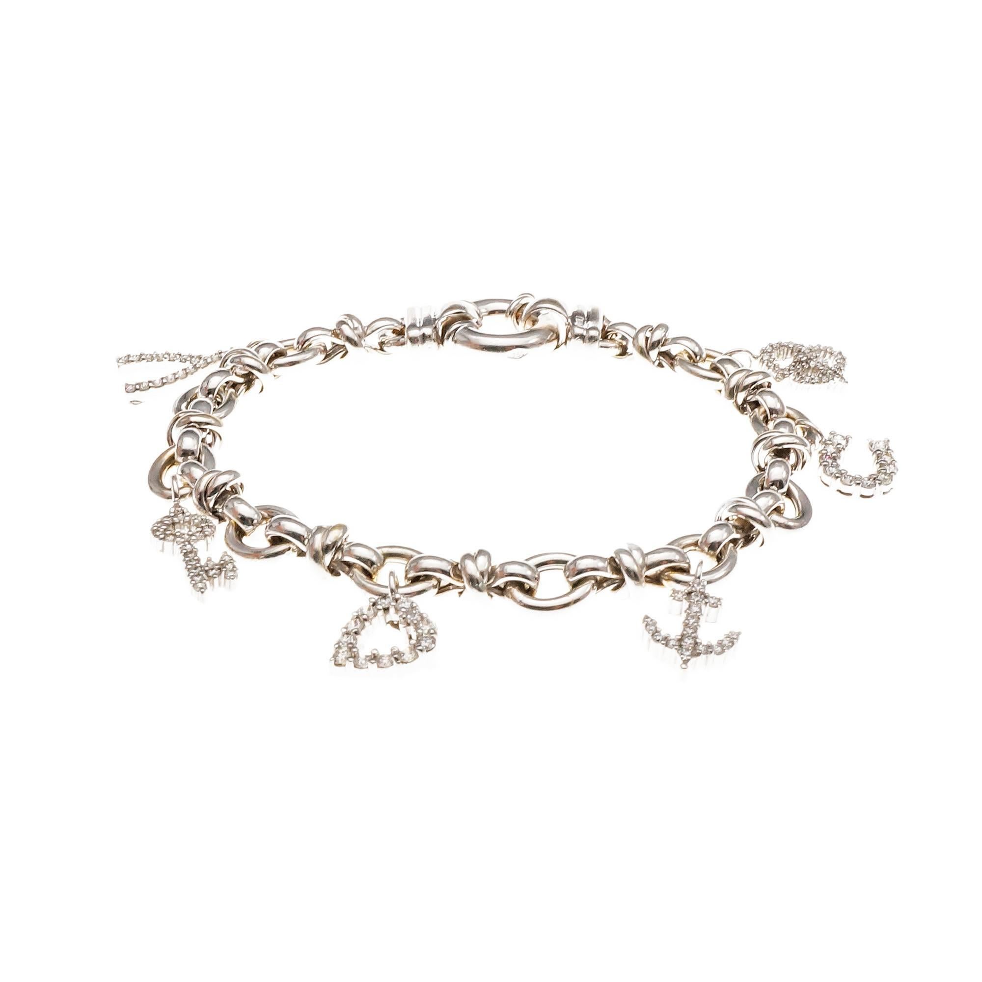 bracelet en or blanc 18 carats avec 6 breloques en diamant. Le bretzel, le fer à cheval, la clé et le bréchet ont un accent en rubis et sont des breloques Roberto Coin vérifiées. L'ancre et le cœur n'ont pas d'accents en rubis. Elles sont en or