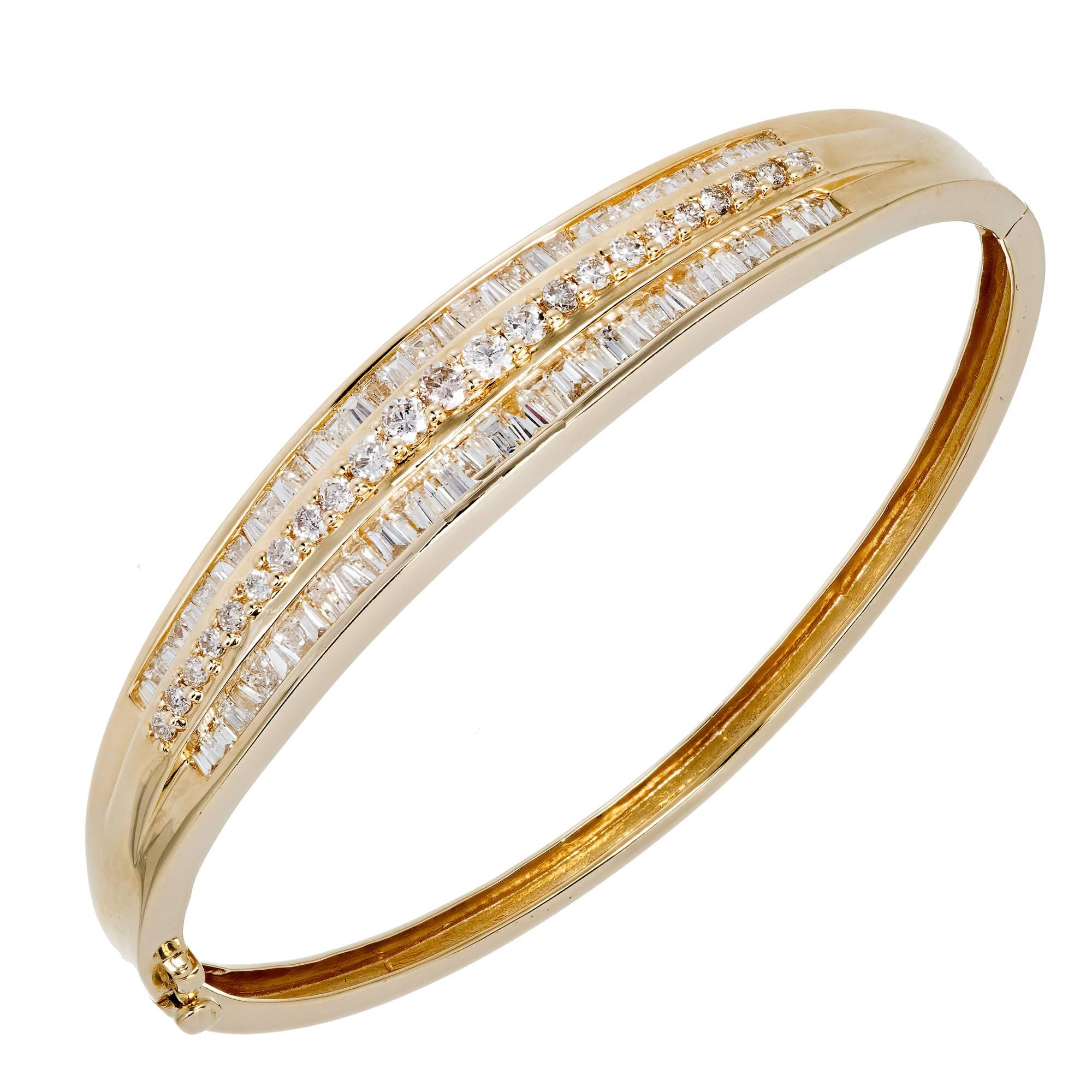 Fine diamond 3 row baguette and round diamond hinged 14 karat bangle bracelet. Underside safety. 

66 baguette cut diamonds, approx. total weight 1.20cts, H, VS-SI
23 round diamonds, approx. total weight .46cts, H, VS
14k Yellow gold
18.6