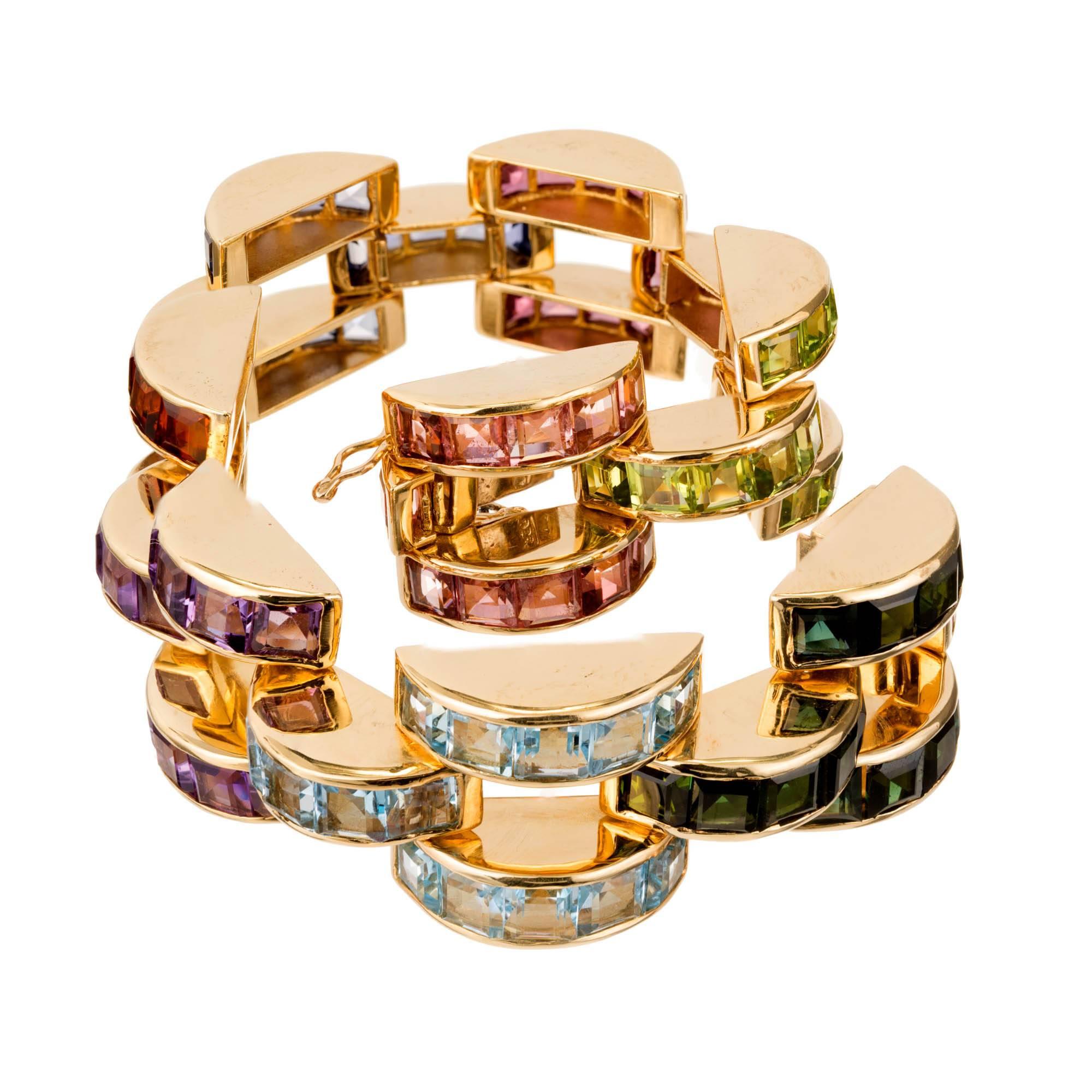 Domed channel set link bracelet with 8 different sets of colored stones of semi-precious varieties all presumed simple heat treated or irradiated, set in 14k yellow gold. 

15 green step cut Tourmaline, approx. total weight 4.00cts, VS, 4.2 x