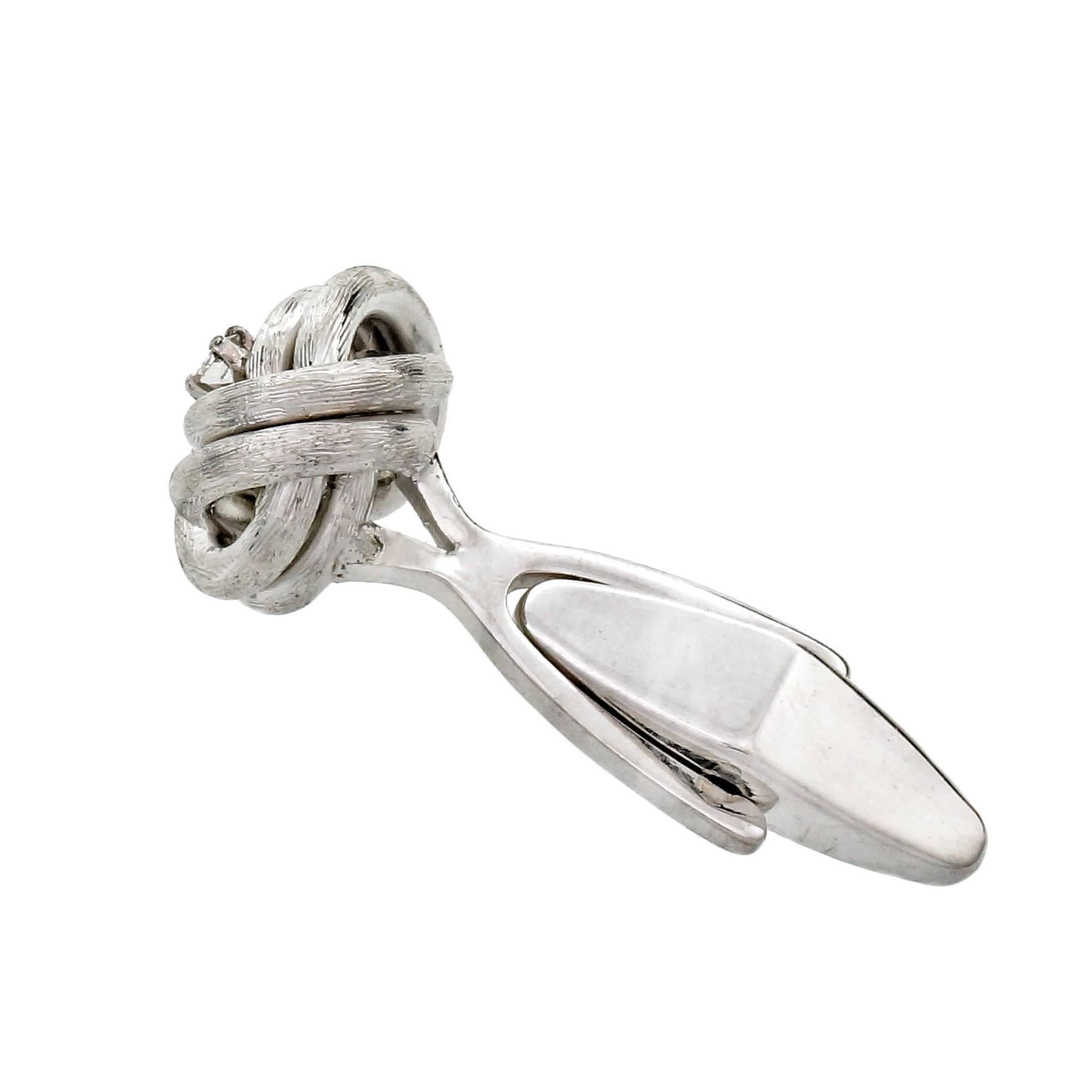 Da Vinci solid heavy textured 14k white gold knot cuff links with bright full cut Diamonds.

14k white gold
2 round Diamonds, approx. total weight .14cts, G, VS2
Top to bottom: 13.33mm or .52 inch
Width: 13.08mm or .52 inch
Depth: 8.95mm
15.1