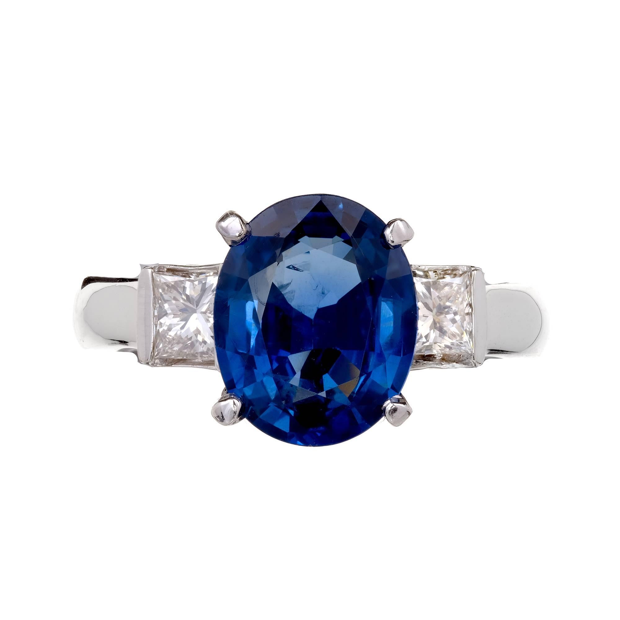 Bright blue oval Sapphire 3.04ct three-stone engagement ring with Princess cut side Diamonds in a 14k white gold setting. GIA certified natural Sapphire simple heat only. 

1 oval bright blue Sapphire, approx. total weight 3.04cts, SI1, 3.53 x