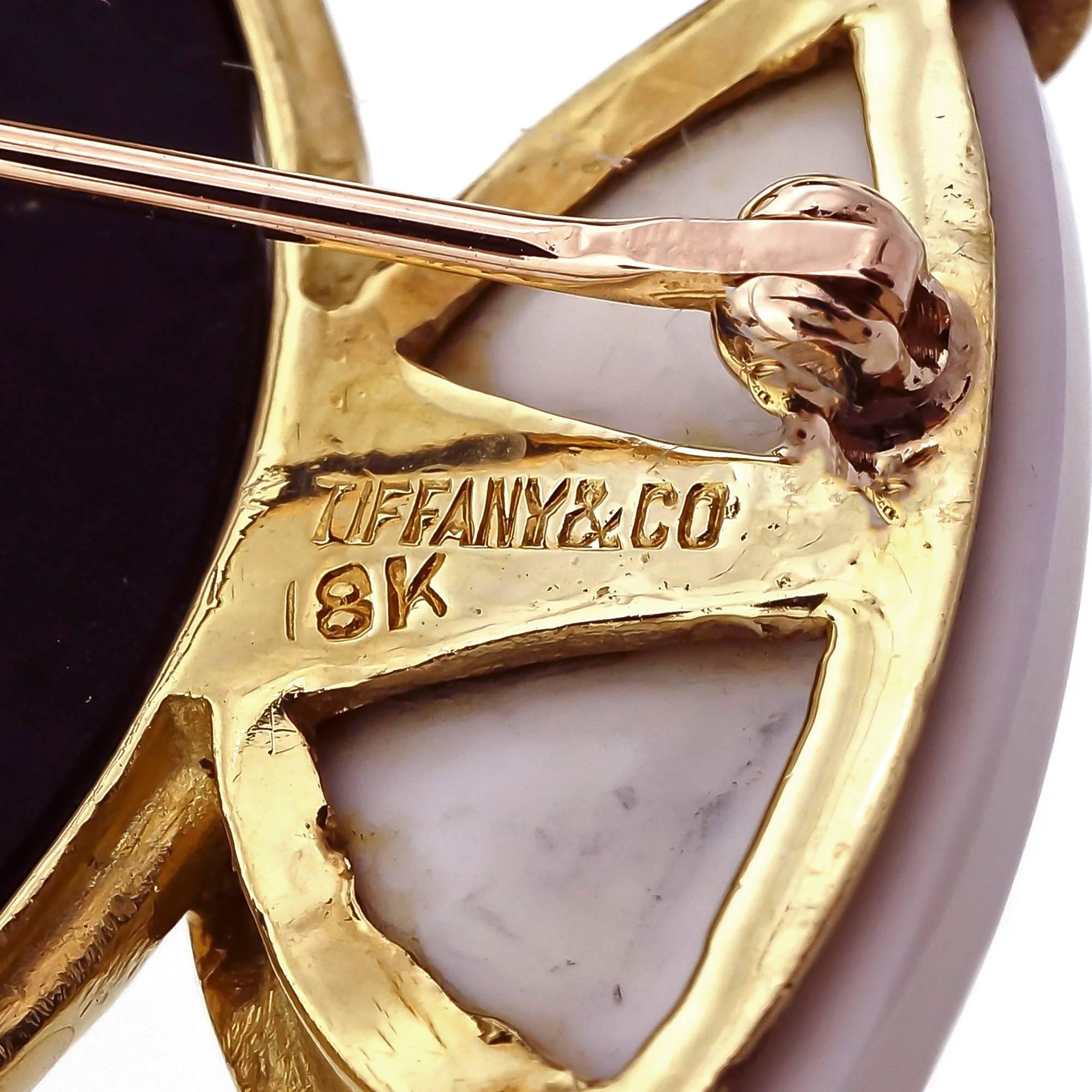 Tiffany & Co 18k yellow gold black Onyx white Pristine brooch pin pendant. Secure pristine and hidden pendant loop.

18k yellow gold
1 round Onyx, 29.62mm
4 fancy white Pristine, 18.03 x 9.05 x 4.11mm
53.5mm or 2.11 inches
Width: 52.91mm or 2.08