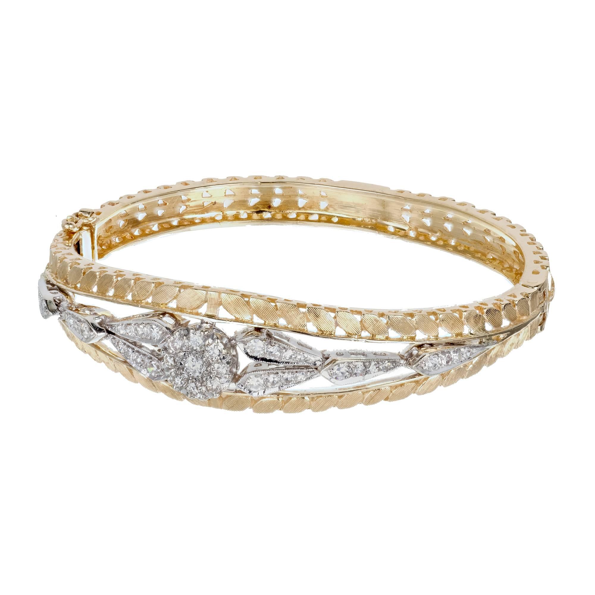 Step back in time with this exquisite Diamond pierced engraved textured gold hinged bangle bracelet from the 1950's. This split bangle bracelet is crafted in 14k yellow gold with a 14k white gold middle bridge that is adorned with 41 round cut