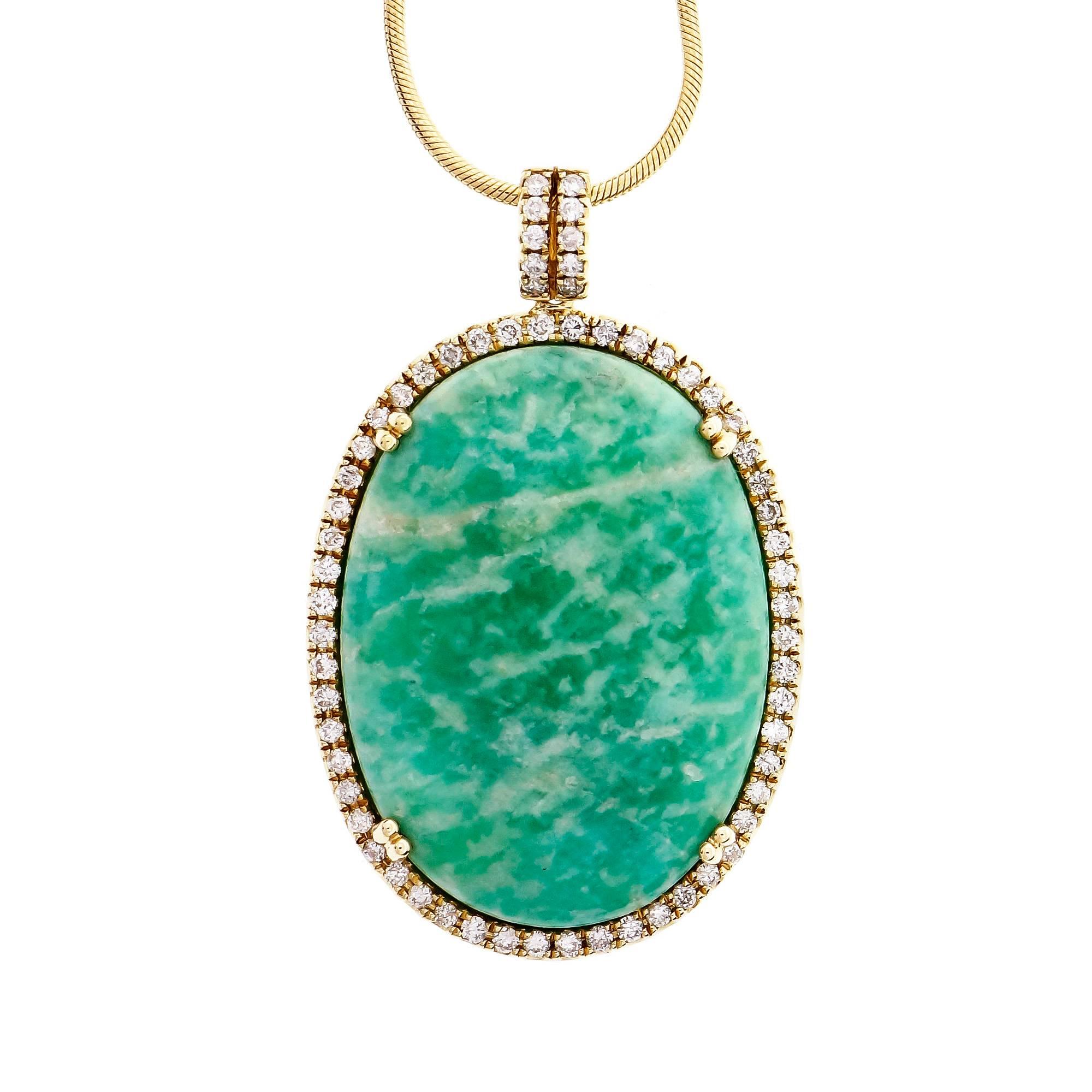 Natural bright green Amazonite pendant in 14k yellow gold with a rim of sparkly full cut Diamonds around the center stone. 18-inch snake chain with lobster catch.

1 oval bright green Amazonite, 29.93 x 22.19 x 4.9mm
64 round Diamonds, approx. total