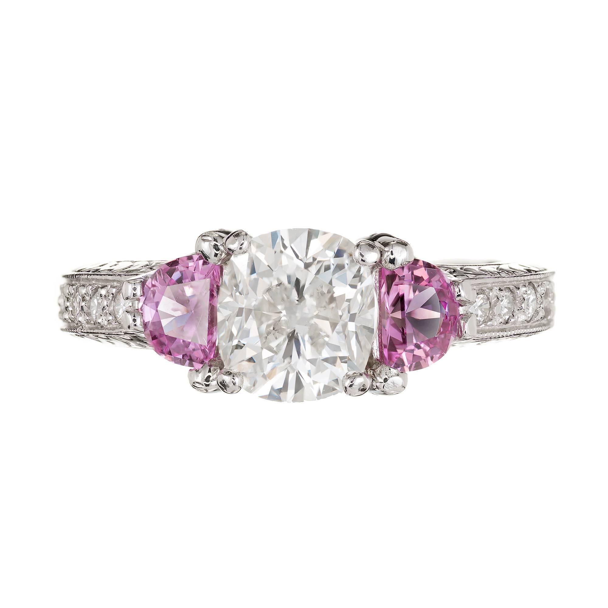 Cushion cut 1.55ct. center diamond in an Antique style platinum engagement ring setting with two half moon pink side sapphires and round diamonds along the shank. Made by the Peter Suchy workshop. Egl Certified

1 Cushion cut diamond Approx. 1.55ct