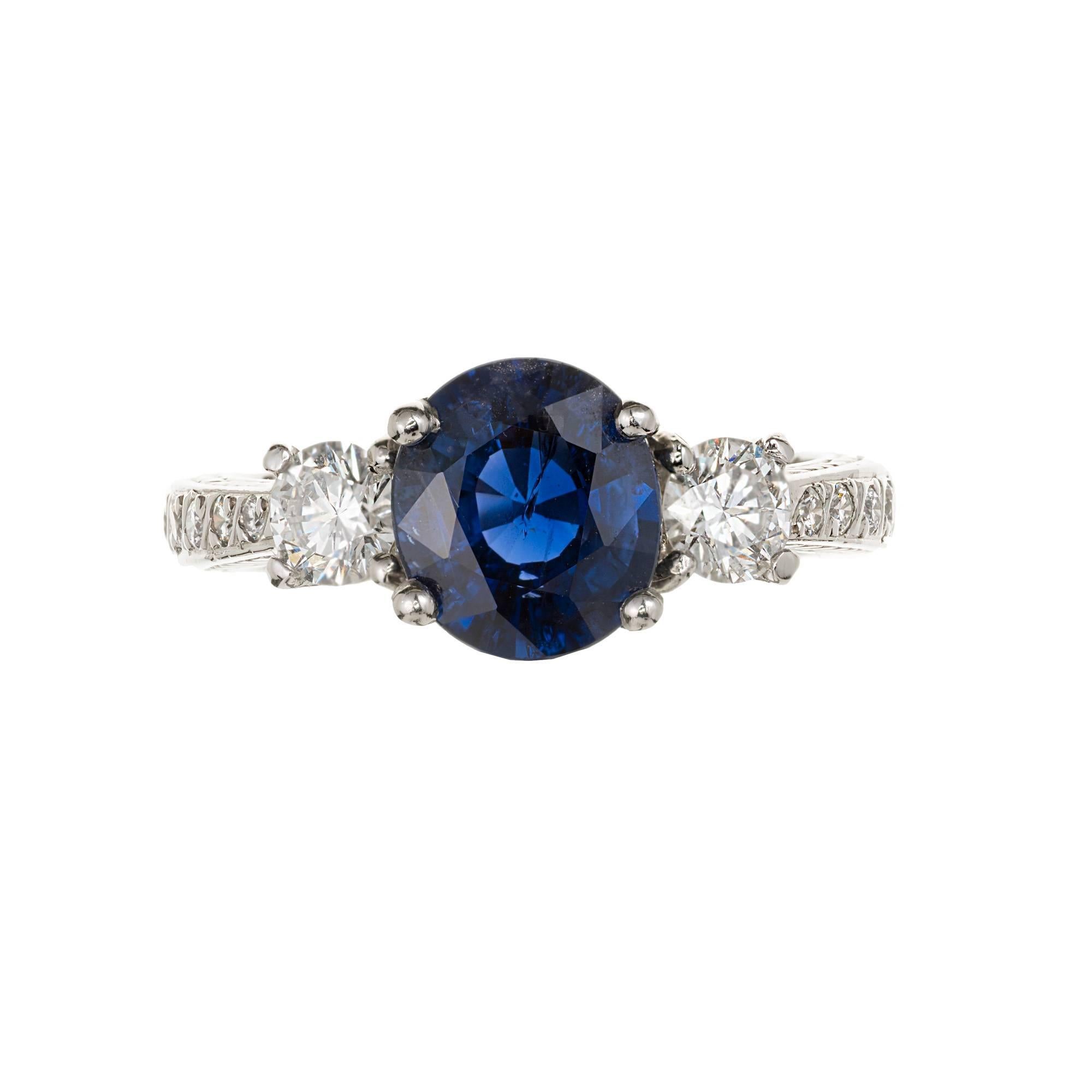 Peter Suchy three-stone sapphire and diamond handmade engagement ring in a Platinum setting with accent diamonds. Royal blue natural no heat cushion Sapphire. GIA certified, 

1 oval cushion shape natural Sapphire no heat and no enhancements, 8.72 x