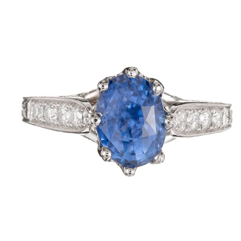 Peter Suchy Cornflower blue oval Sapphire with a slight purple tone 2.91ct,  AGL certified natural, no heat and no enhancements.  The Sapphire is in a handmade solid Platinum 8 prong engagement ring setting with diamonds along the shank and
