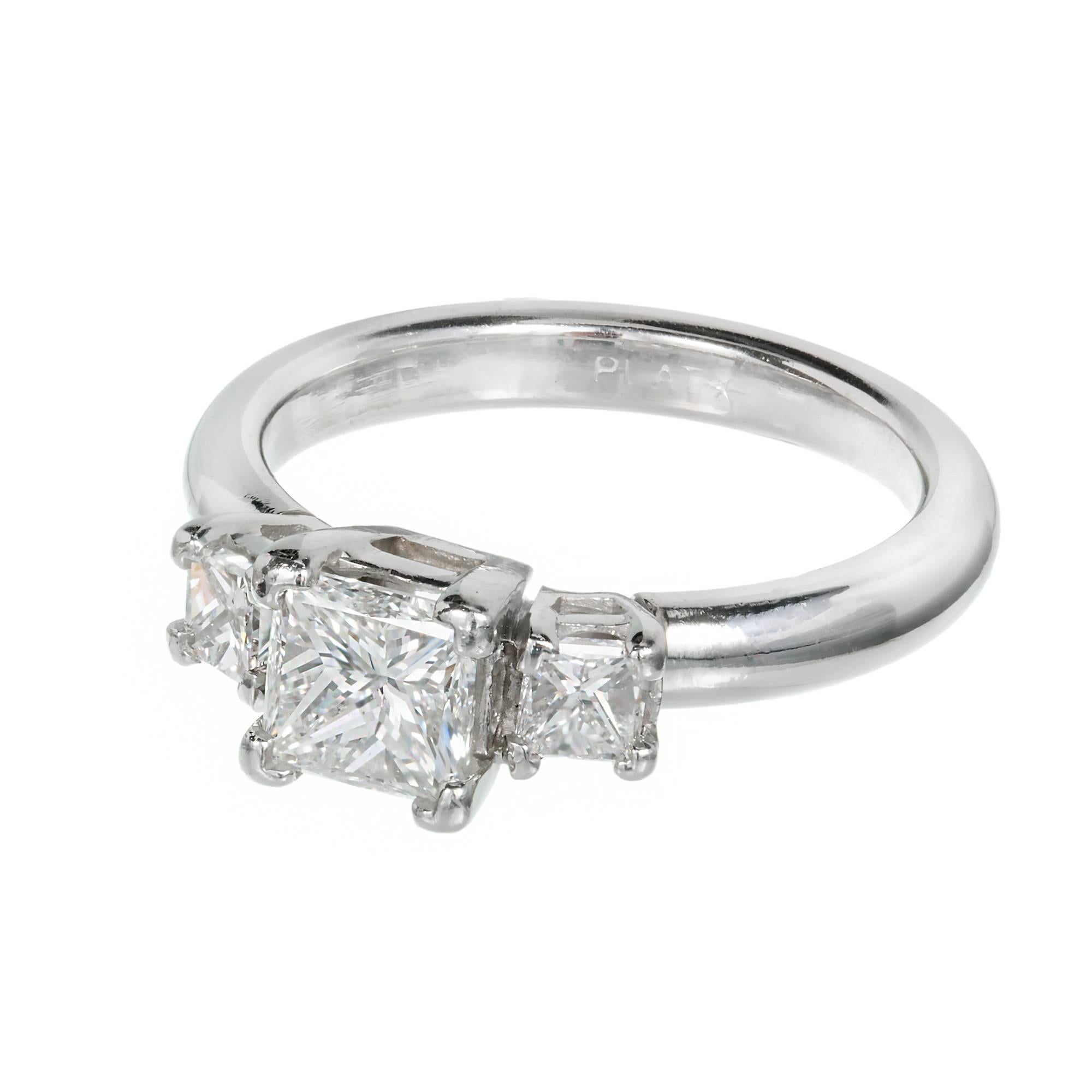 Three princess cut diamond engagement ring in a three stone platinum setting. 

1 Center diamond 1.12cts F, SI1, 
2 Princess cut diamonds Approx. .40cts total F, VS2 to SI1
Size 7 and sizable
Platinum
3.2mm shank
