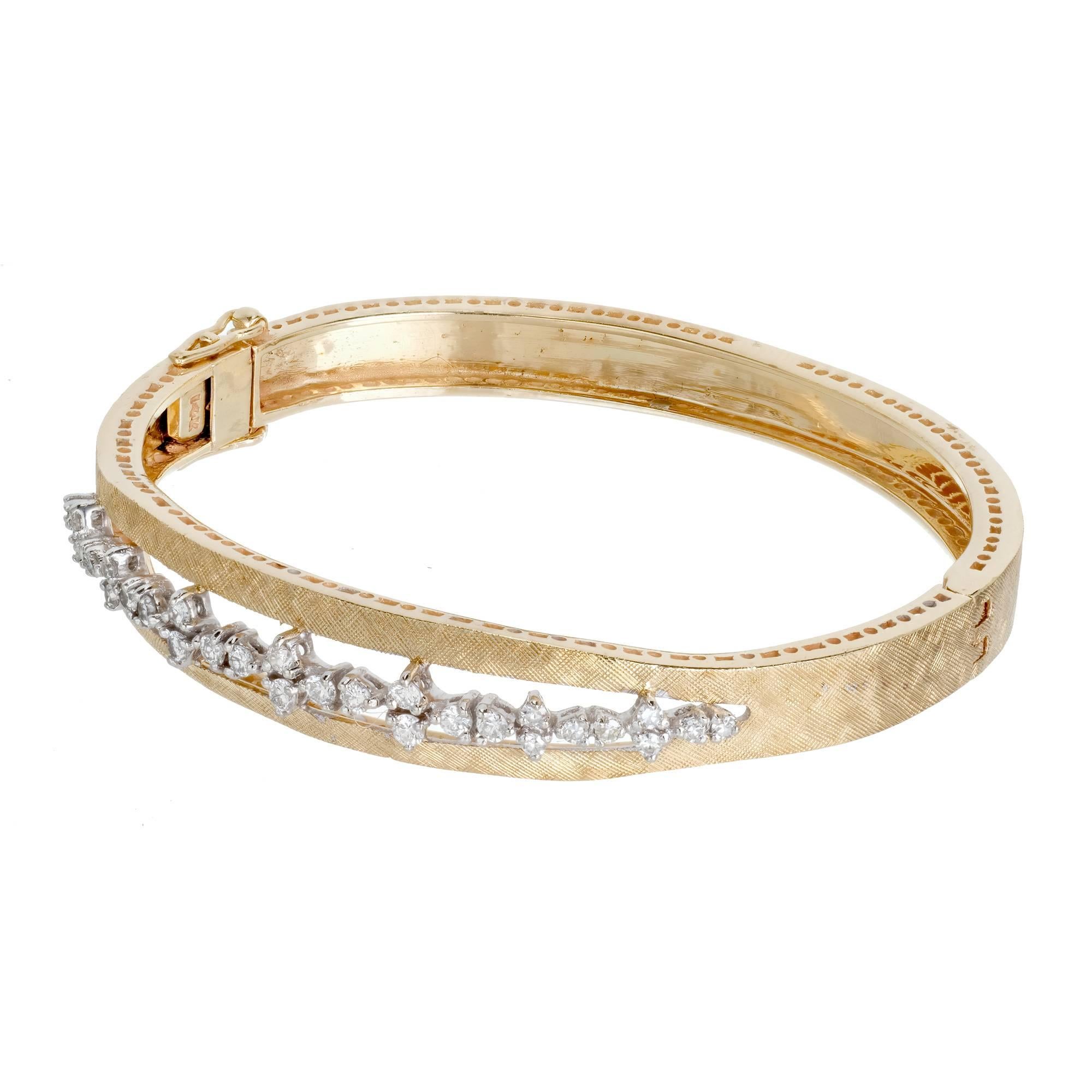 1960's Diamond bangle bracelet. This exquisite 14k yellow gold bangle bracelet features 30 round diamonds set in a 14k white gold center bridge, totaling .98 in carats. The mesmerizing Mid-Century design showcases intricate and meticulous hand
