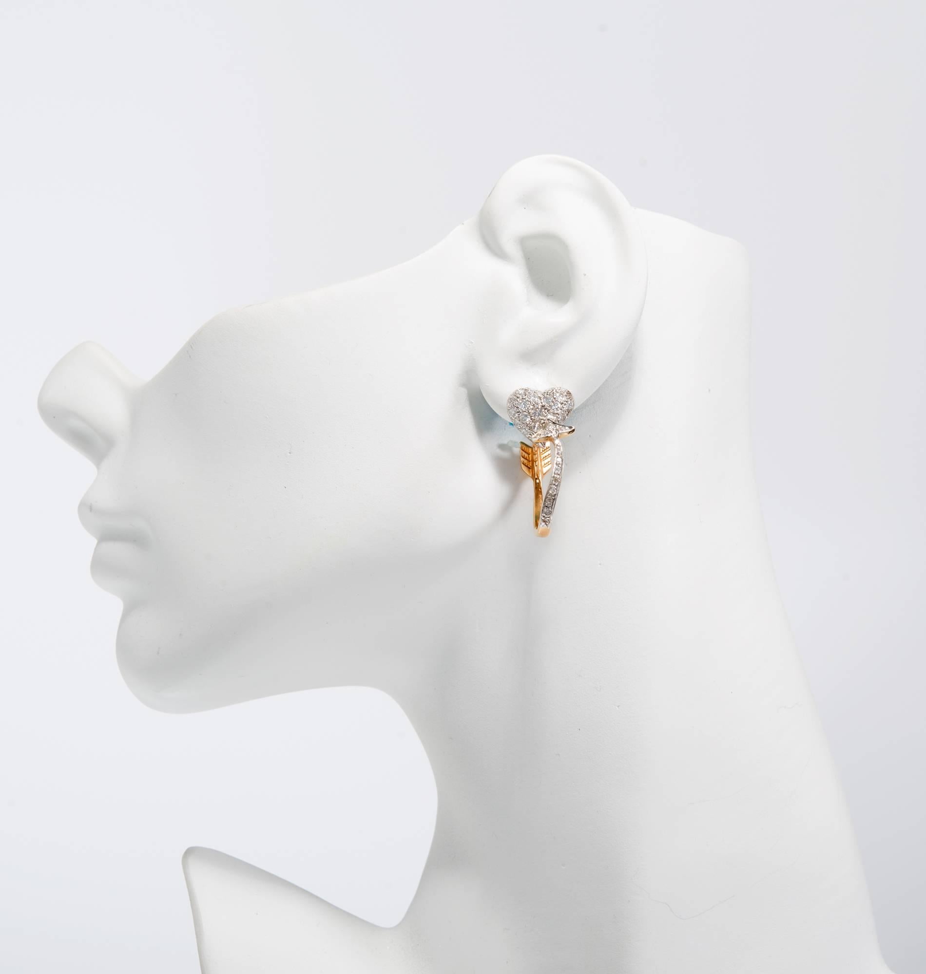 Diamond heart with a yellow gold curved arrow hoop earrings set in 14k white and yellow gold.

90 round diamonds approx. total weight 1.50cts, G, VS-SI1
14k White Gold and yellow gold. 
Stamped: 14k
9.5 grams
Hearts: ½ inch across
Top of heart to