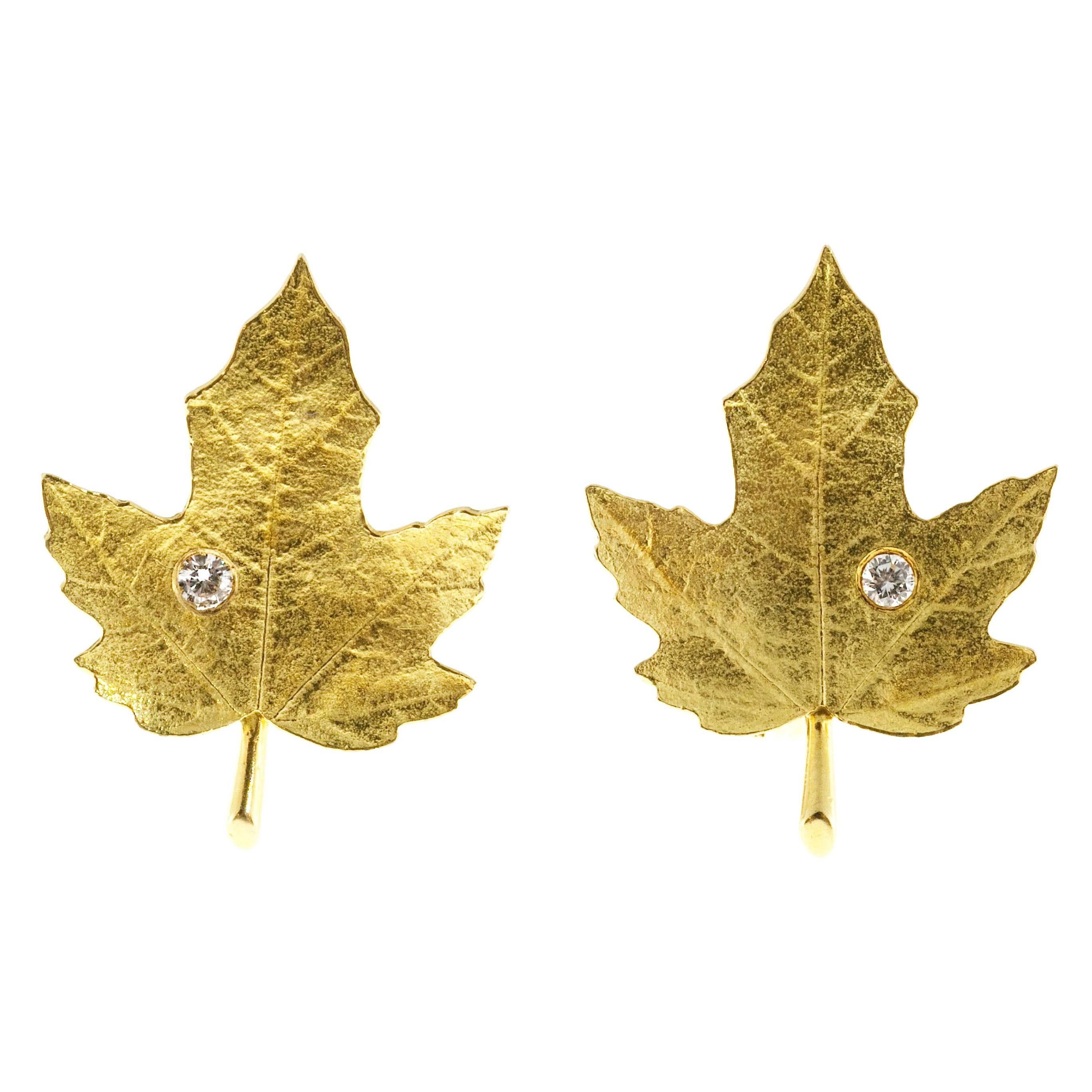 Tiffany & Co 18k textured maple leaf design non pierced adjustable clip earrings. Each leaf with one full cut diamond. Circa 1950 to 1959.

2 round diamonds .10cts each, F, VS
18k Yellow Gold
Stamped: Tiffany + Co 18k PAt2423905 JP
8.5