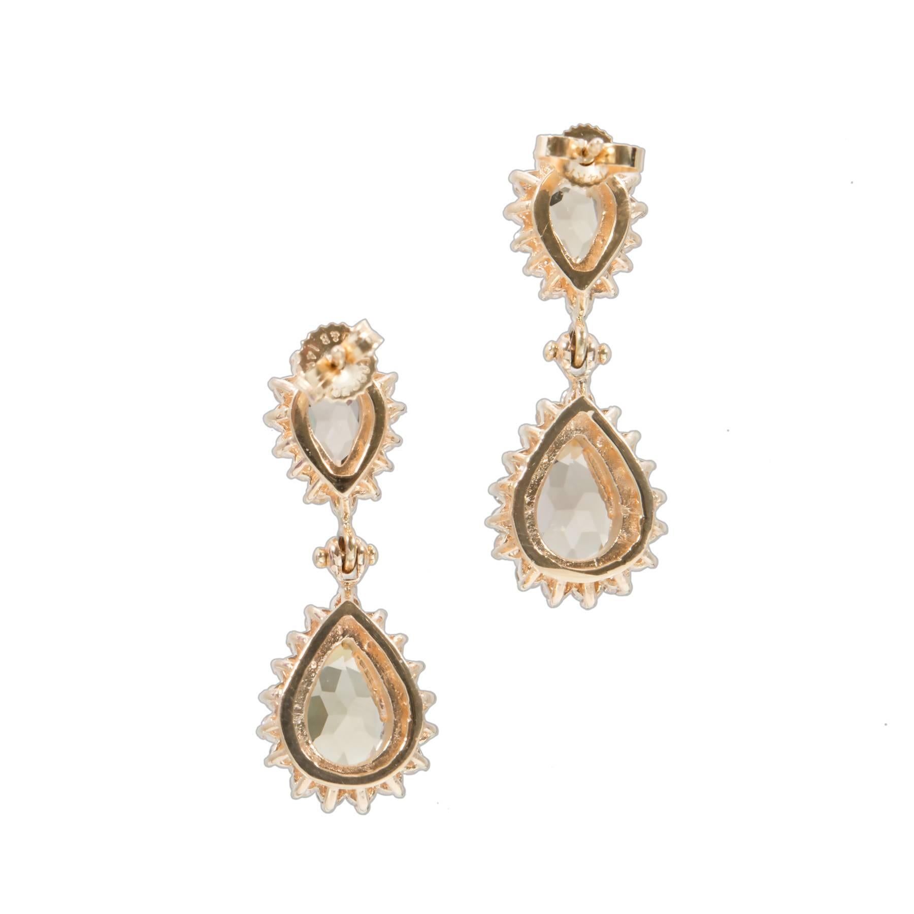 Hinged two section smoky oval Topaz and diamond dangle earrings. Handmade raised wired settings, with full cut round halo diamonds.  

62 round diamonds approx. total weight 1.43cts, G, SI.
4 pearl shape smoky Quartz approx. total weight 6.50cts
14k