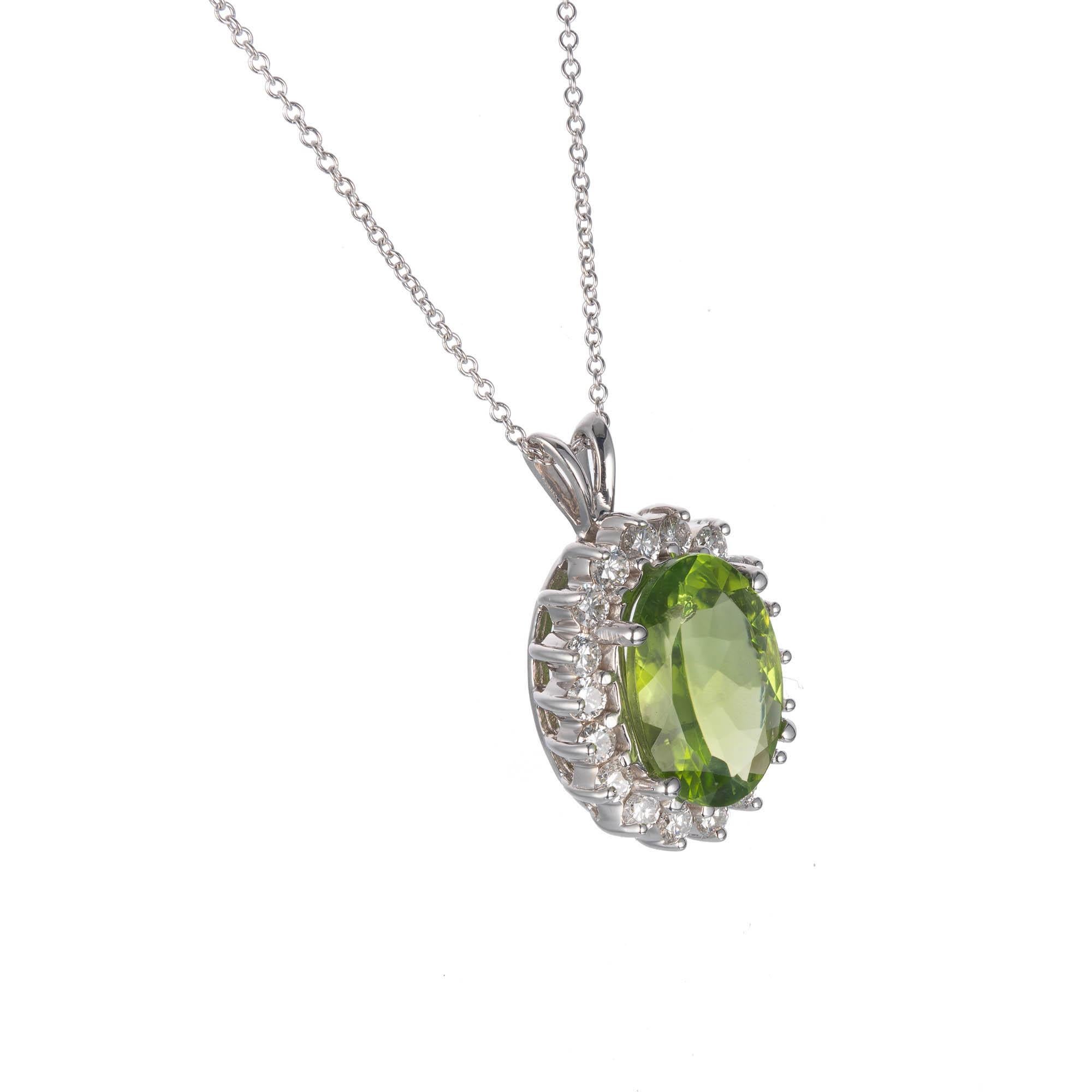 Oval bright green Peridot pendant with bright white diamond halo, on an 18 inch white gold chain. 

1 13.8 x 10mm oval bright green Peridot, approx. total weight 3.50cts,
18 round full cut diamonds, approx. total weight .90cts, G-H, SI1
14k White