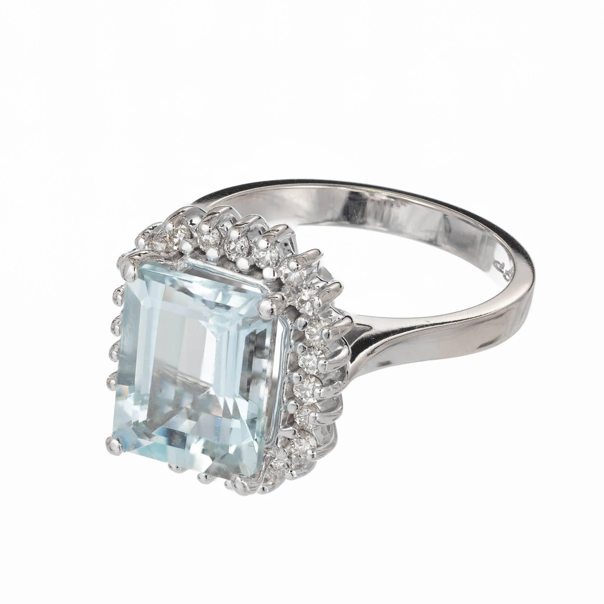 Bright natural untreated slightly greenish blue natural Aqua and diamond halo cocktail ring. In a 14k white gold setting surrounded by a halo of diamonds.

1 Emerald cut bright greenish blue Aqua, approx. total weight 3.00cts, VS, 10.2 x 8.2mm
24
