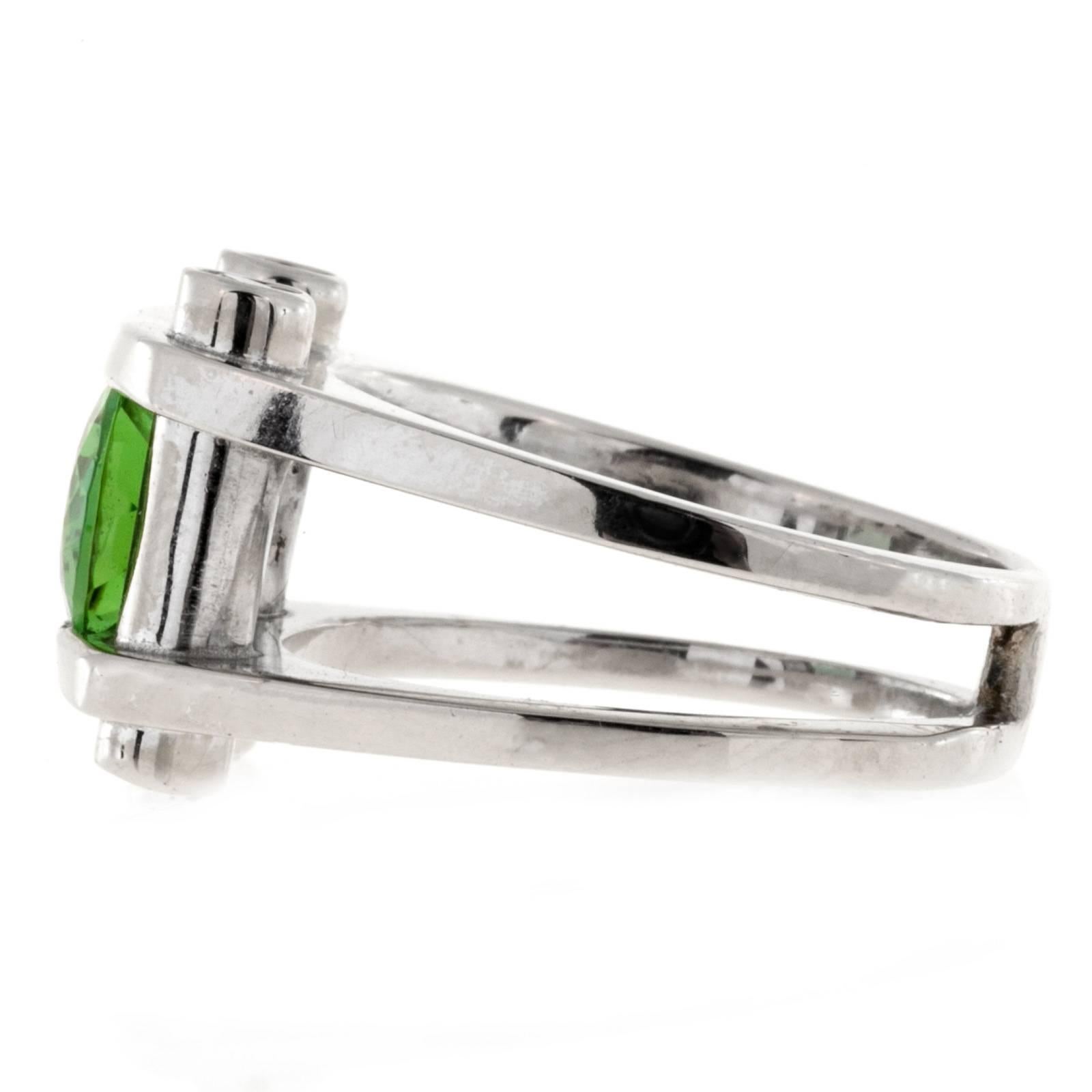 Bright green oval Tourmaline and diamond white gold ring.

1 bright green tourmaline 10 x 8mm oval, approx. total weight 2.90cts
4 full cut diamonds, approx. total weight .05ct each, G, VS2 to SI1
14k White Gold
11.7 grams
Width at top: