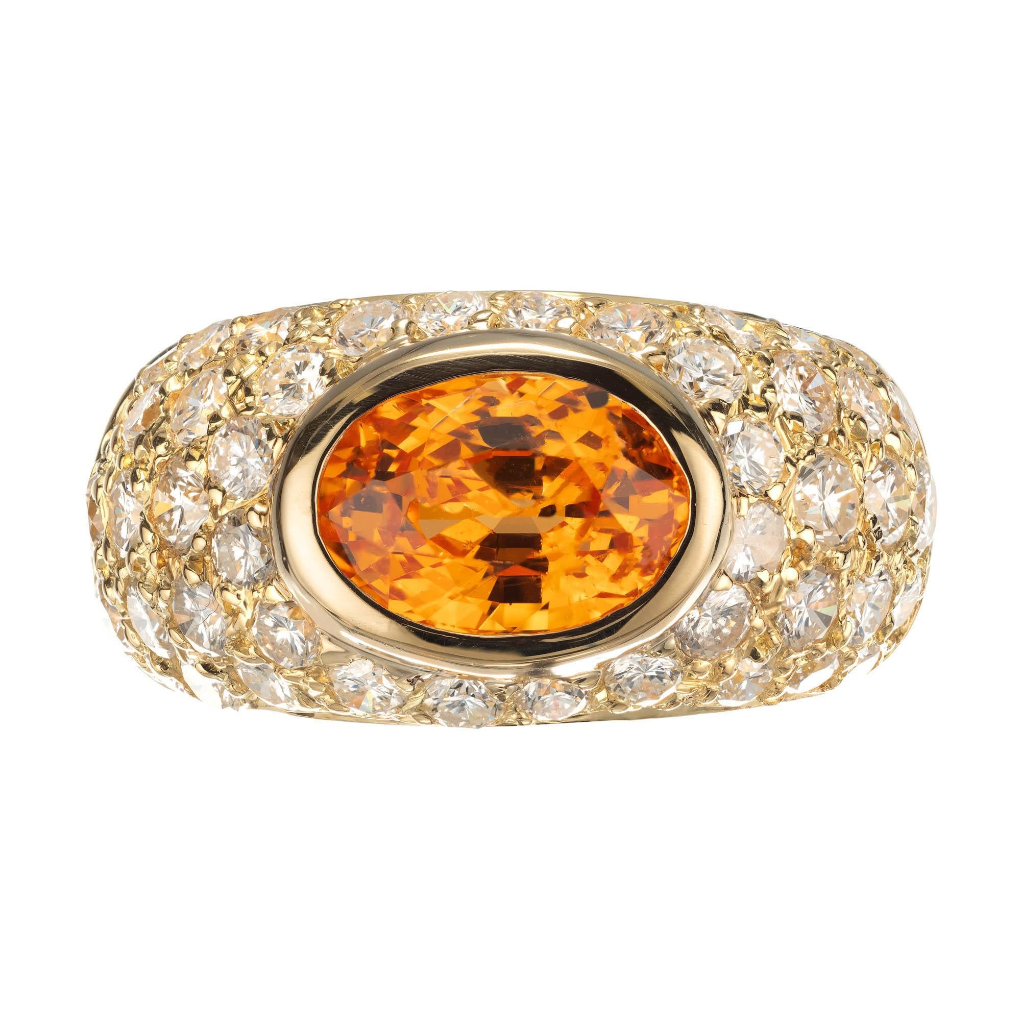 1960's Mid-Century vibrant Spessartite Garnet and diamond dome cocktail ring. 2.43ct Oval orange bezel set sideways Spessartine in a beautiful handmade dome 18k yellow gold setting with a cluster of 45 round pave set diamonds.  

1 oval bright