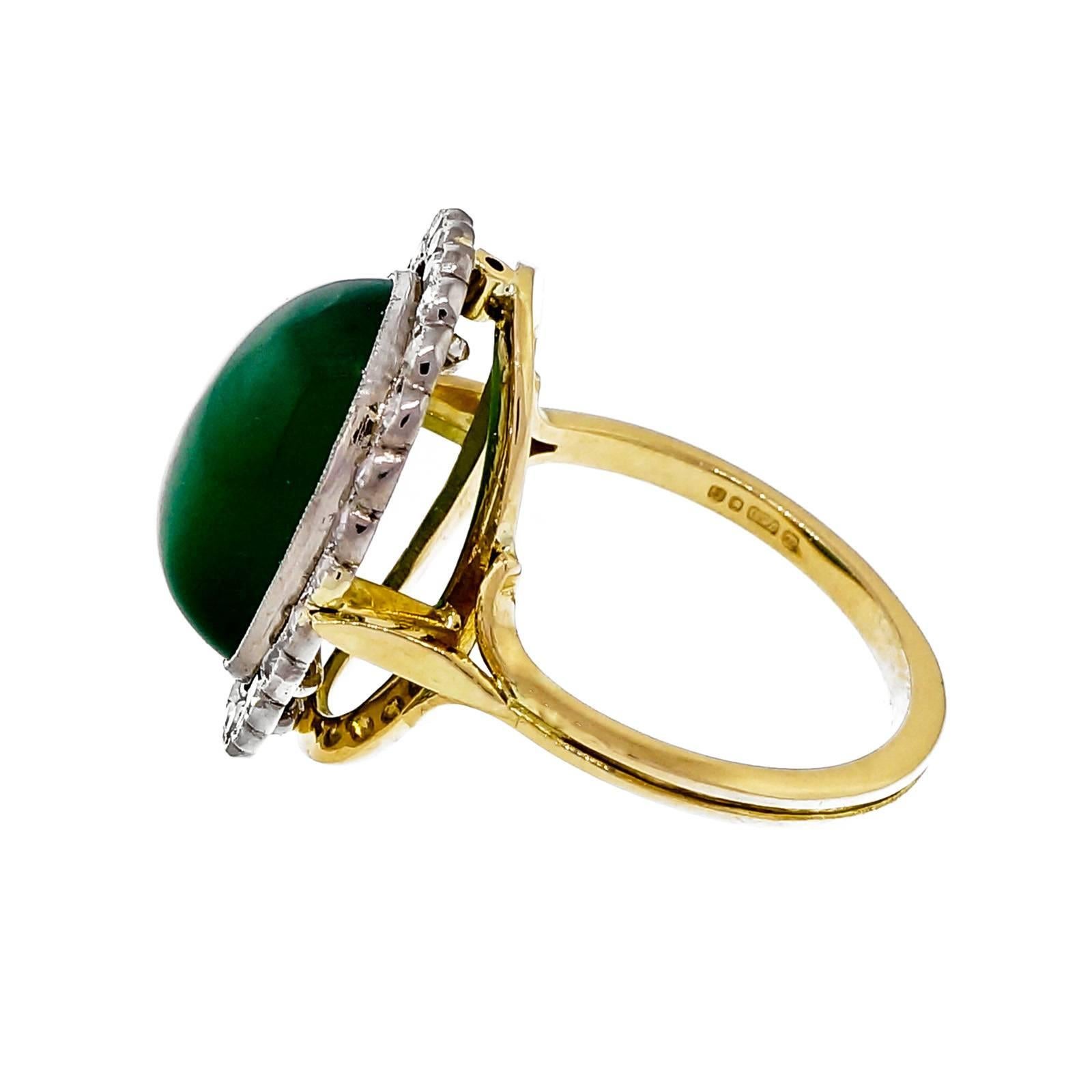 Vintage 1930-1940 translucent green Onyx set in a scalloped border cluster ring with European single cut diamonds.

18k white and yellow gold
1 oval green translucent Onyx, approx. total weight 3.00cts, 14.87 x 10.40mm
28 old European single cut