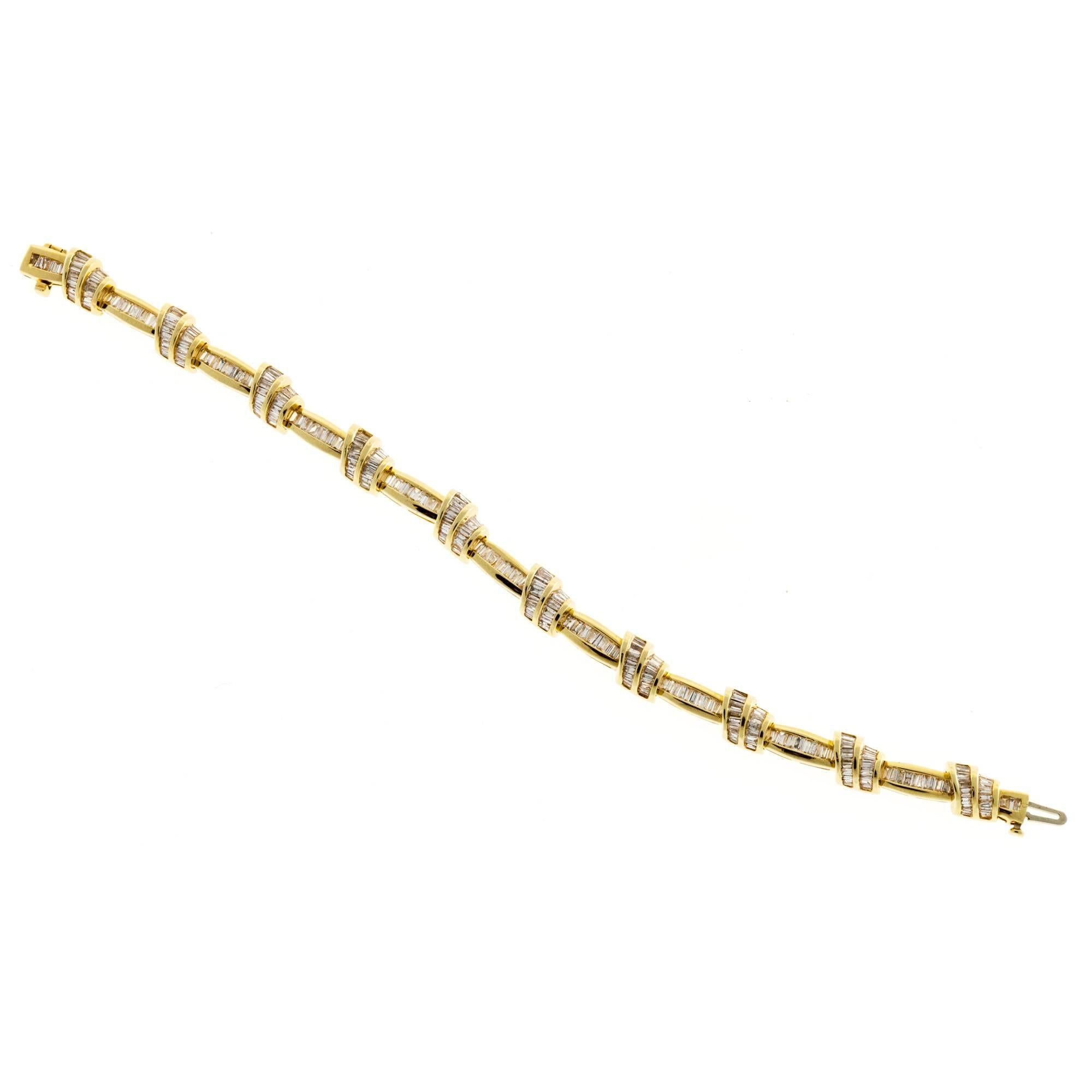 Solid 14k yellow gold channel set bracelet with double swirl alternating with straight sections all set with baguette diamonds end to end. Designer SRT. Set with a total of 279 baguette diamonds, H-I and VS-SI clarity. There are a few gaps between