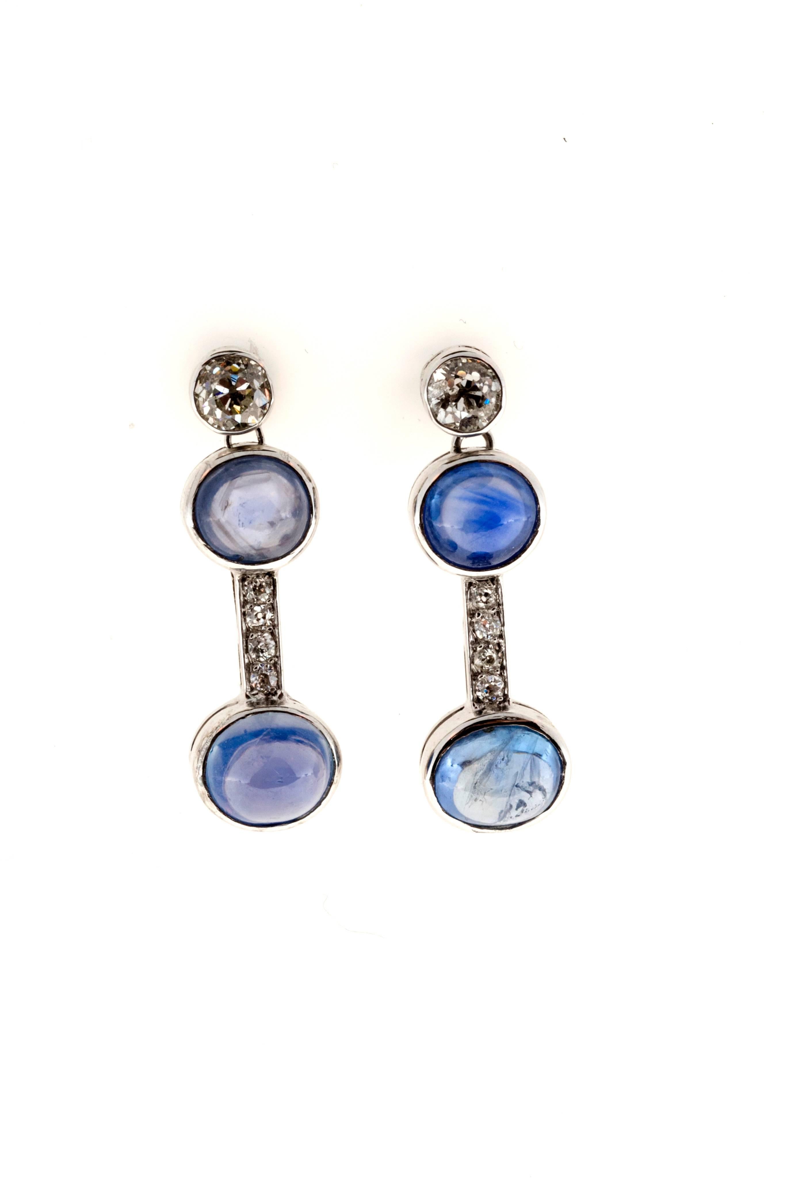 Platinum dangle earrings with old mine cut diamonds on top and Ceylon Sapphire cabochons with a diamond bar in-between
4 natural light to medium blue cabochon genuine Sapphires.

2 old mine cut diamonds, approx. total weight.70cts, G - H, VS2 -