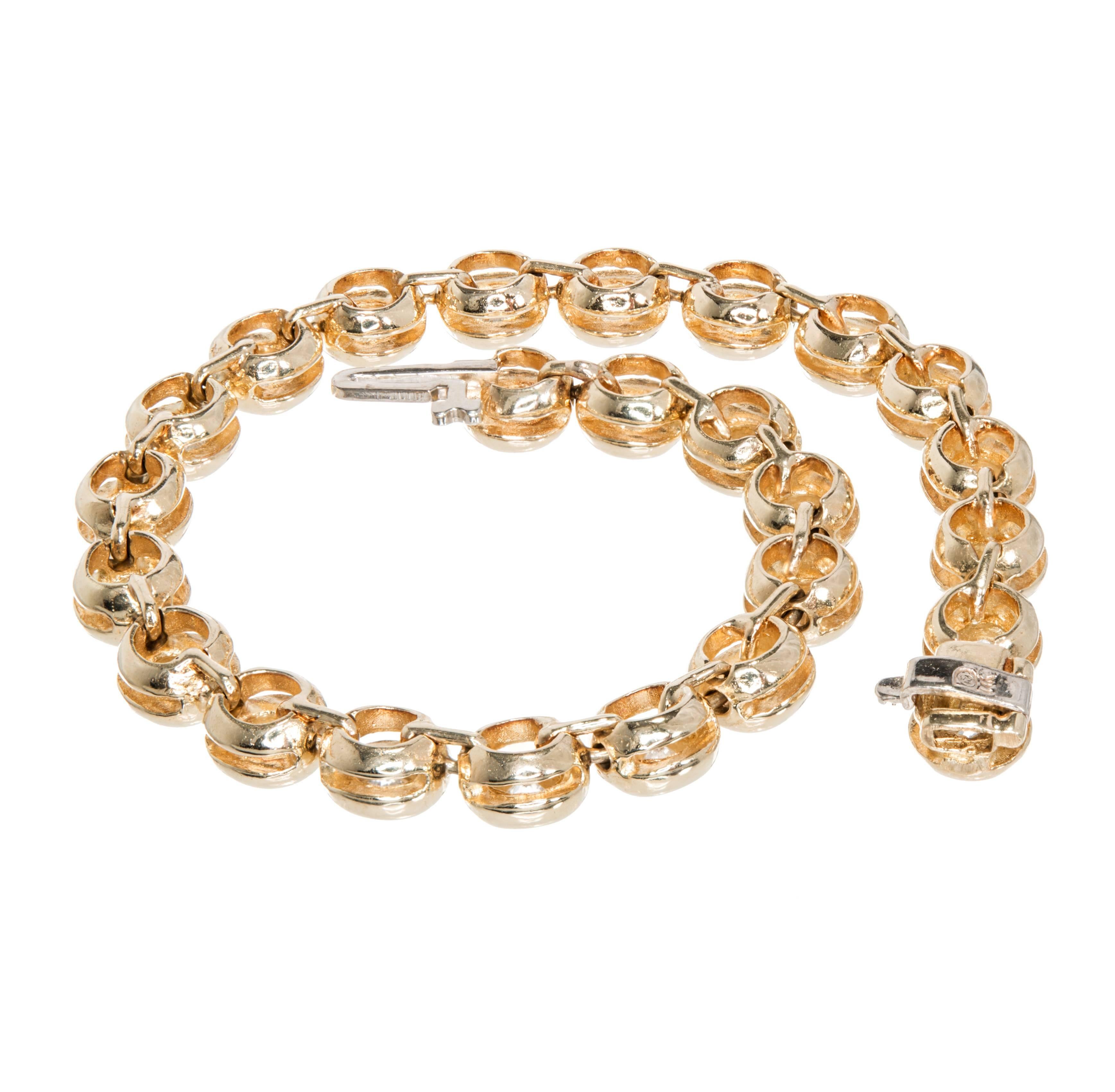 Diamond hinged bracelet. Set in 14k  yellow gold, this bracelet features 25 brilliant cut diamonds totaling 5.25cts. Each diamond is set in a bubble style bezel set tube. The yellow gold setting enhances the brilliance of the diamonds, adding warmth