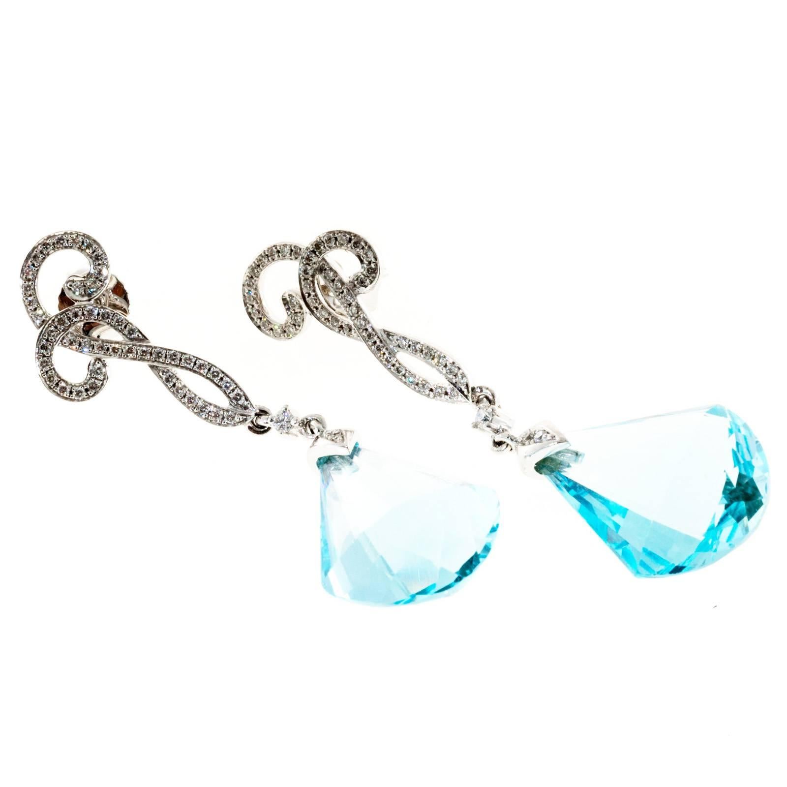Cordova 14k white gold diamond dangle earrings with blue Topaz.

2 fancy blue Topaz, 18.57 x 13.21 x 7.01mm
92 round diamonds, approx. total weight .33cts
18k white gold
Tested and stamped: 18k
Hallmark: Cordova
7.6 grams
Top to bottom: