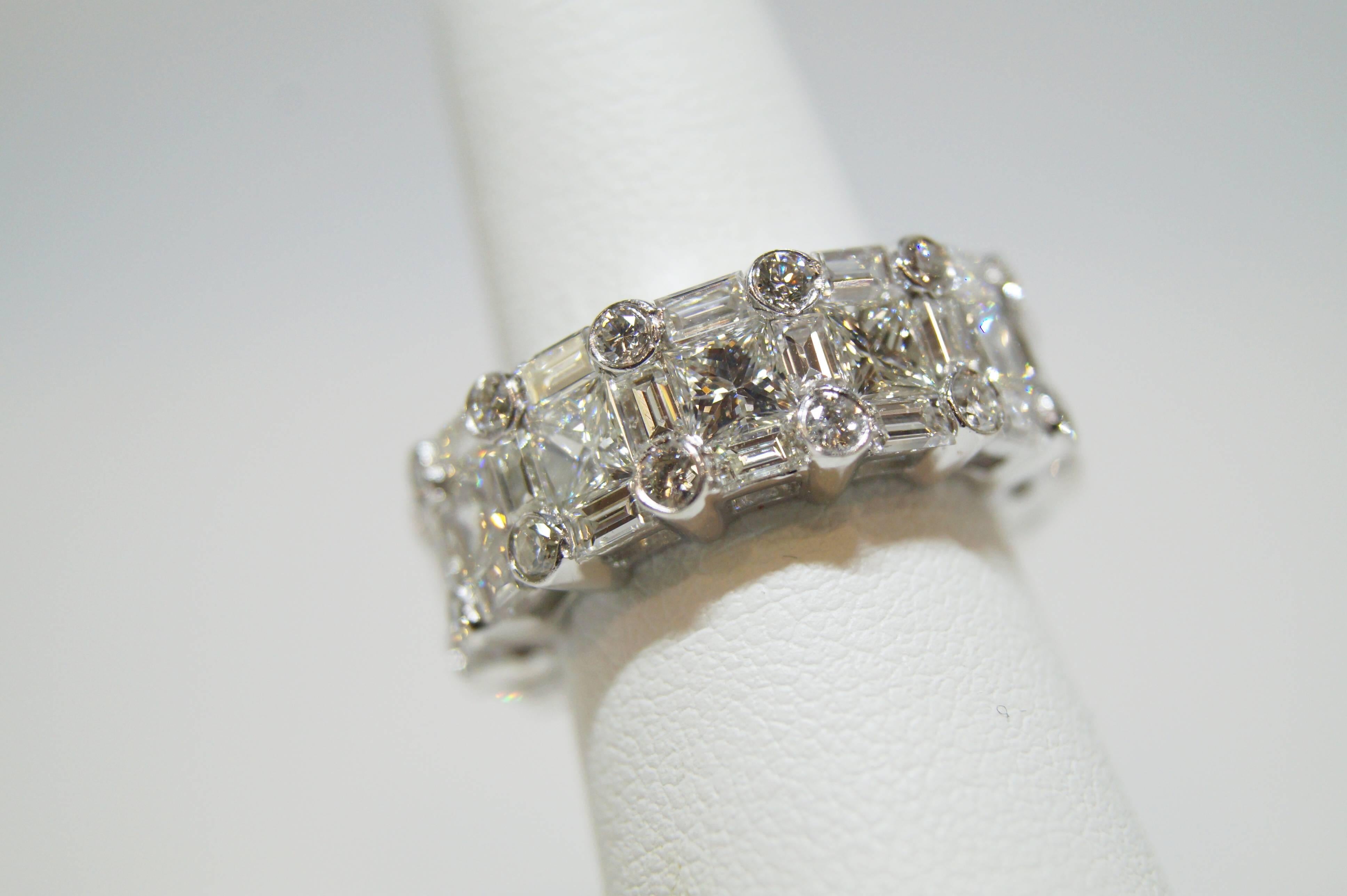 This unique eternity wedding band features 13 Princess cut diamonds 3.67 cts, 40 Baguette diamonds 3.02 cts and 26 full cut round diamonds weighing 0.30 cts. The diamonds are G in color, and VS in clarity