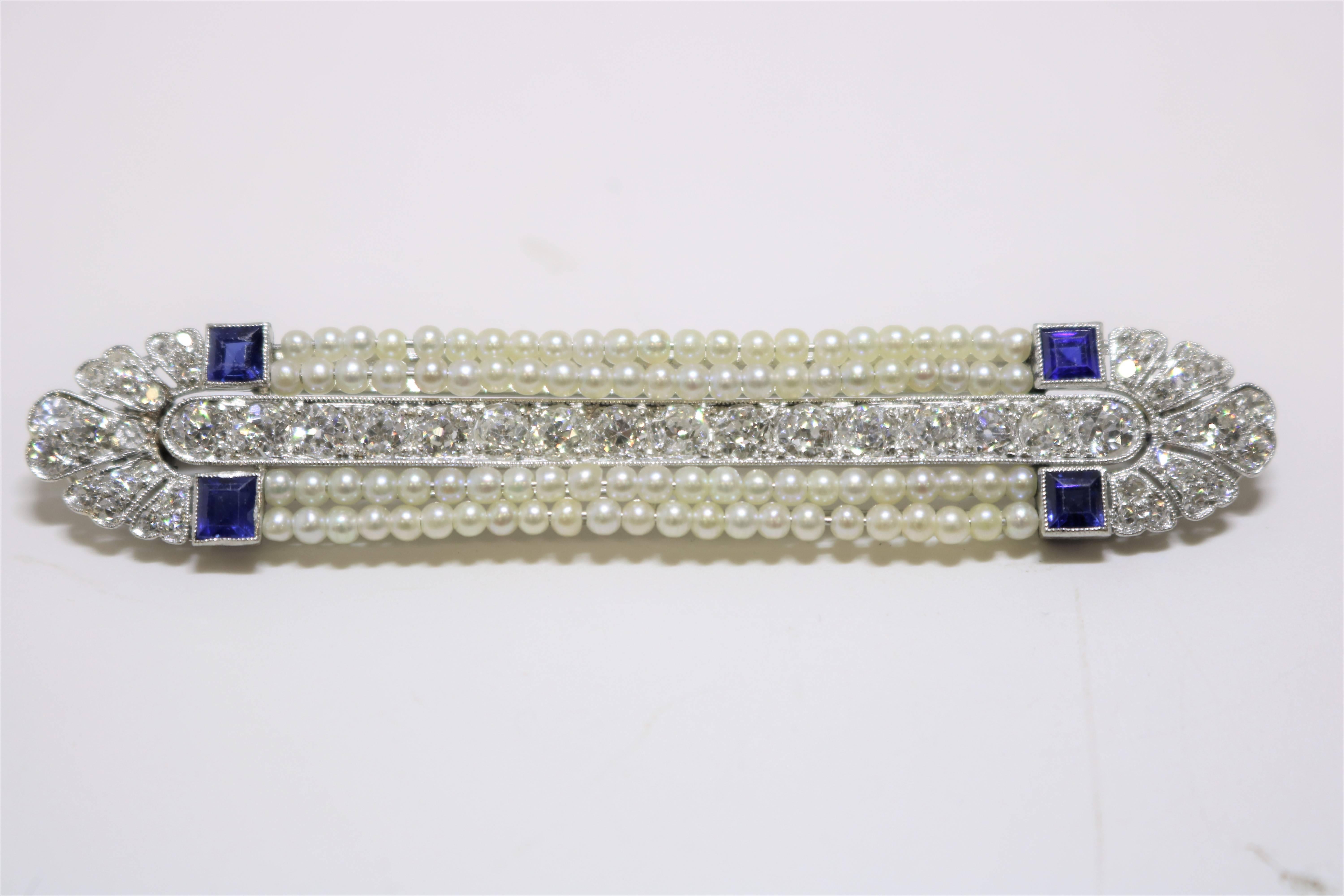 This Art Deco Diamond, Sapphire and Seed Pearl Brooch features 52 diamonds weighing approx. 3.00 ct, 4 square sapphires weighing approx. .80 ct  set in Platinum.