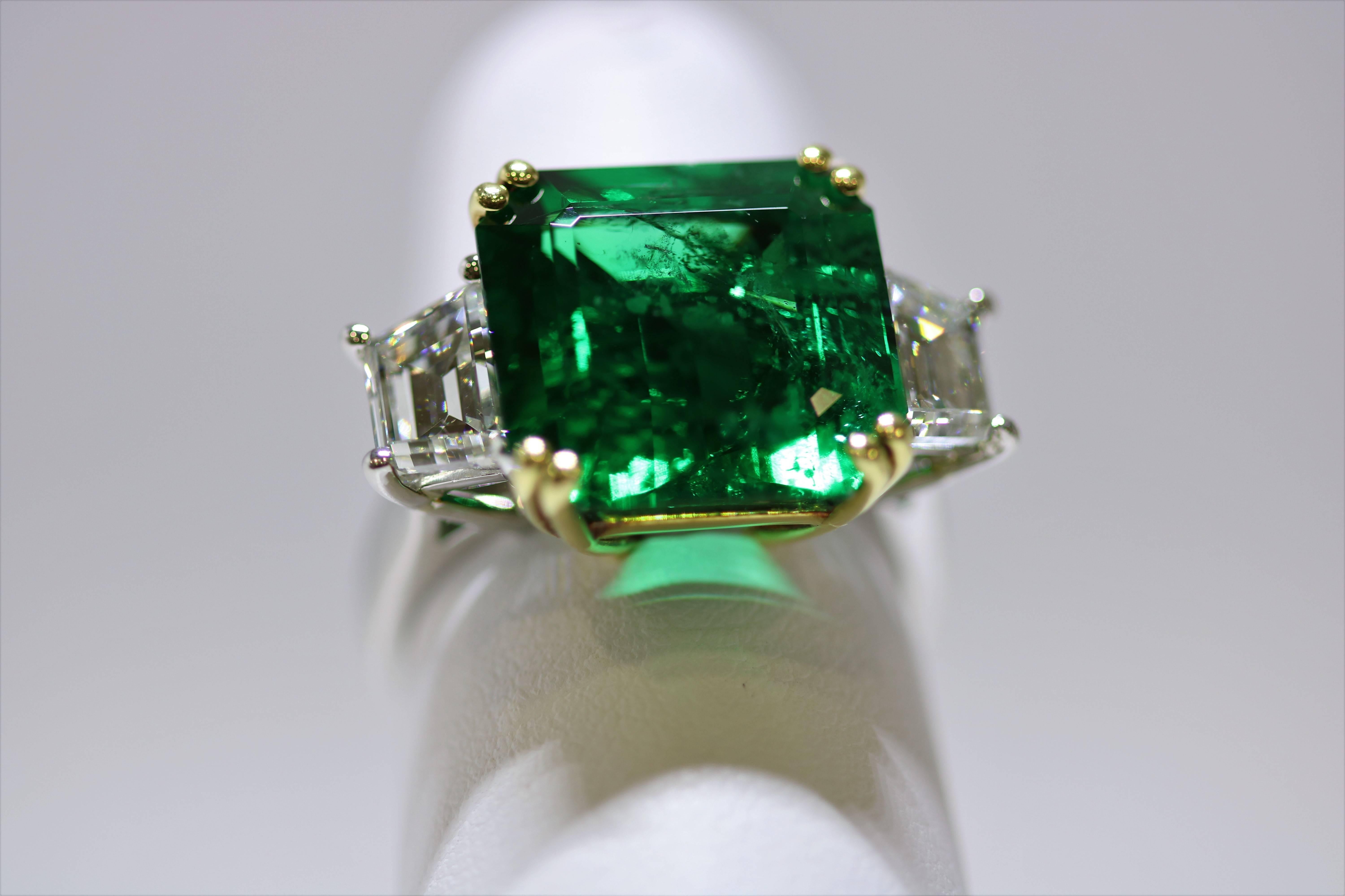 This very fine emerald and strikingly beautiful diamond ring features a 9.02 ct   square Emerald stone with 2 fine trapezoid diamonds, 2.21 ct total weight; Emerald is Zambias, extremely fine and intense green color, excellent brilliance in an 18k