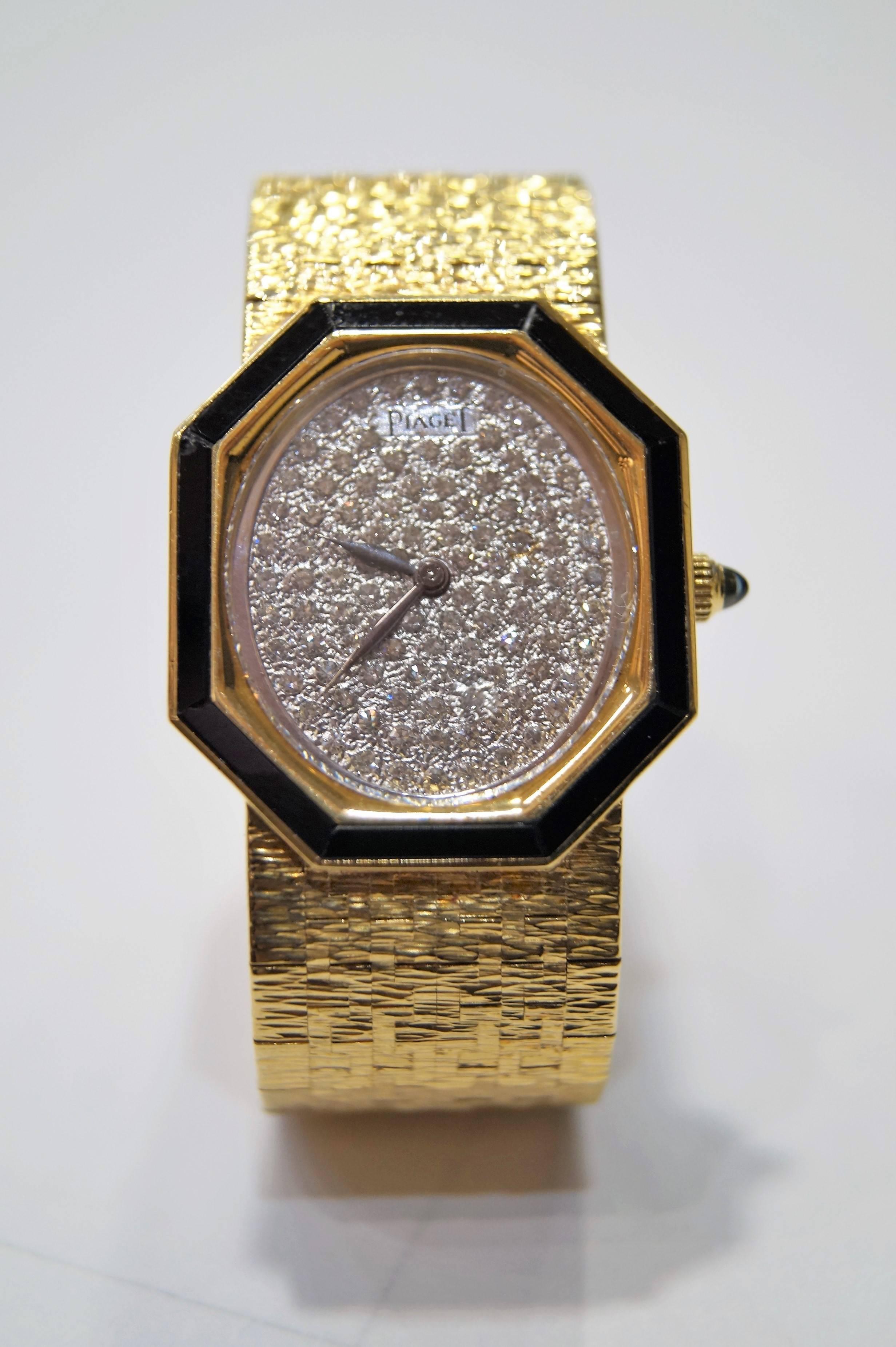 This classic circa 1970's 18k Yellow Gold Piaget Ladies Watch has a bark style bracelet with a black onyx octagon bezel and a pave diamond dial. The watch has 17 Jewel Swiss movement