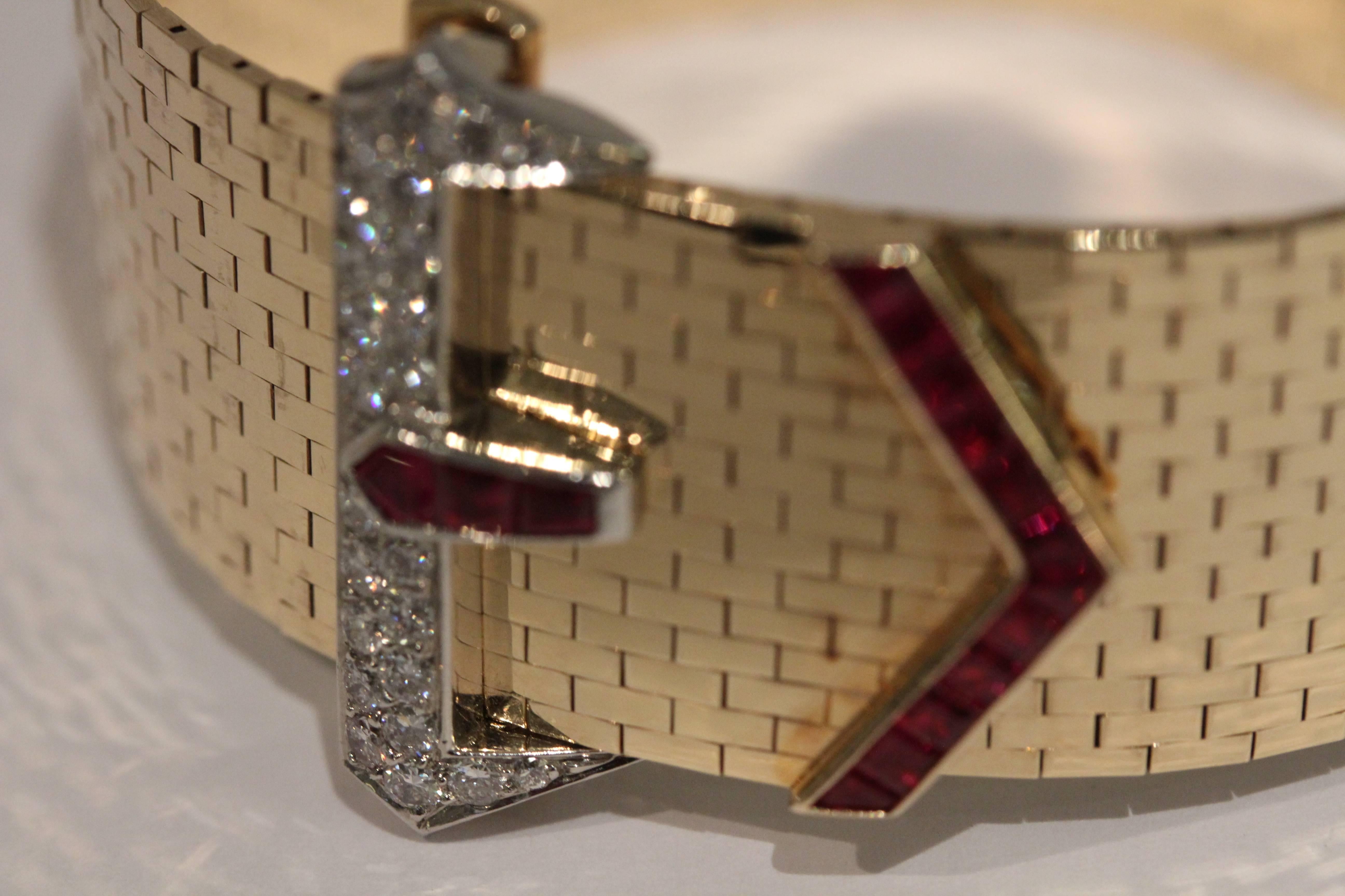 14 Karat yellow and white gold Tiffany And Company diamond and ruby buckle bracelet. The 24 round diamonds weigh .64 total carat weight. The 15 square and trapezoid rubies weigh 1.05 total carat weight.
