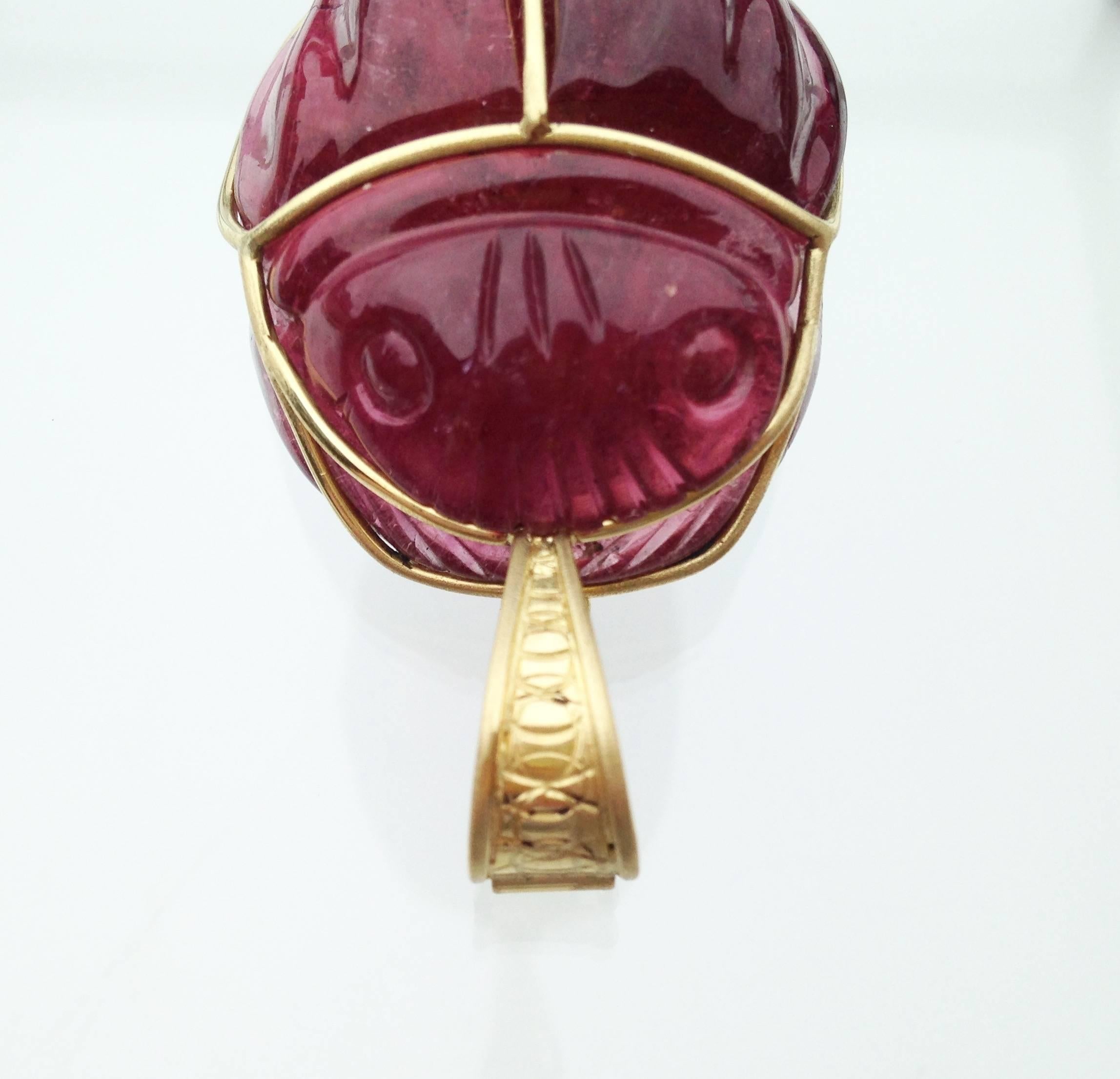 Susan designed this Hand Carved  Rubellite Scarab Beetle Pendant set in an 18kt Gold Bale Frame.  With a well engineered clasp, the Scarab Beetle can hang from a chain or beaded necklace.  Detailed engraving on the front of the clasp finishes off