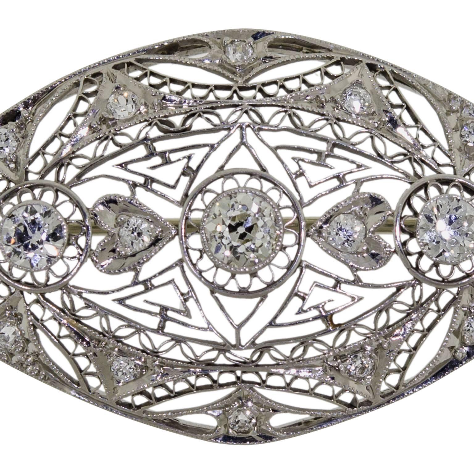 Charming lady's circa 1920 Art Deco 14kt white gold and diamond brooch set with numerous Old European Cut diamonds with a total approximate weight of 1.33 ct. set in a beautiful 14kt white gold filigree and heart motif mount. Lovely lively old cut