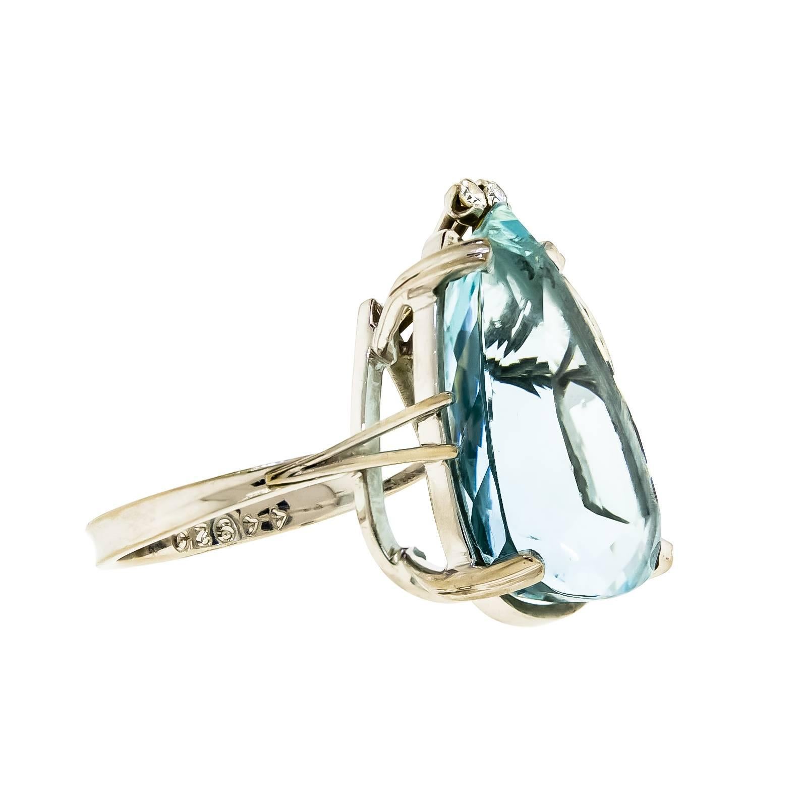 This large yet elegant mid-century aquamarine and the diamond cocktail ring is sure to draw attention. The beautiful crystal blue hue that radiates from the impressive pear-shaped aquamarine pair perfectly with the sublte glow of the 18 karat white