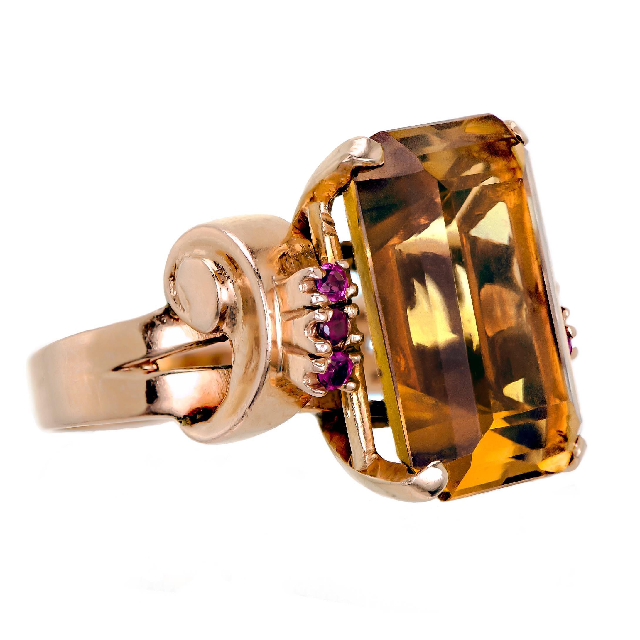 Retro citrine, ruby, and 14 karat yellow gold ring set with one large step cut citrine further accented with six small round faceted rubies into a heavy 14kt yellow gold ring mount. The citrine measures approx 18 mm length by 13 mm width and 8mm