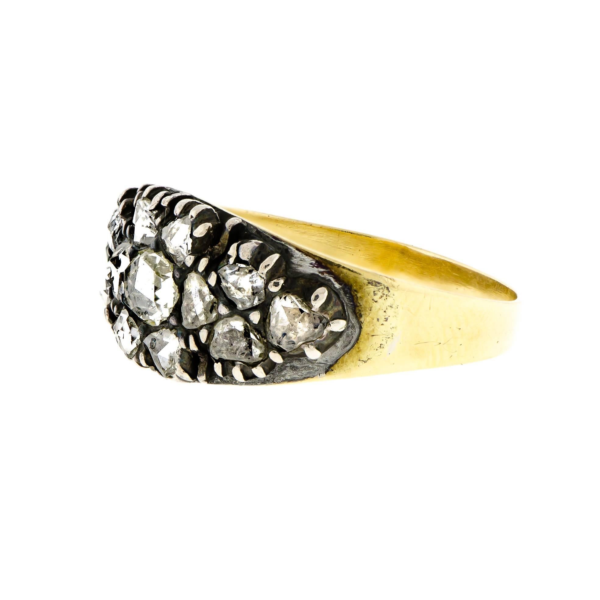 Early Victorian antique silver topped yellow gold rosecut diamond ring consiting of thirteen (13) prong set closed back mounting rosecut diamonds of varying sizes, chunky cuts set into a silver topped yellow gold band ring.