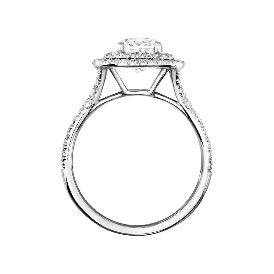This exquisite diamond ring has a central 1.25 ct cushion cut diamond (E VVS1), elegantly surrounded by vibrant pave brilliants. The ring is crafted in delicate 18 karat white gold and is also available in yellow gold, rose gold and platinum upon