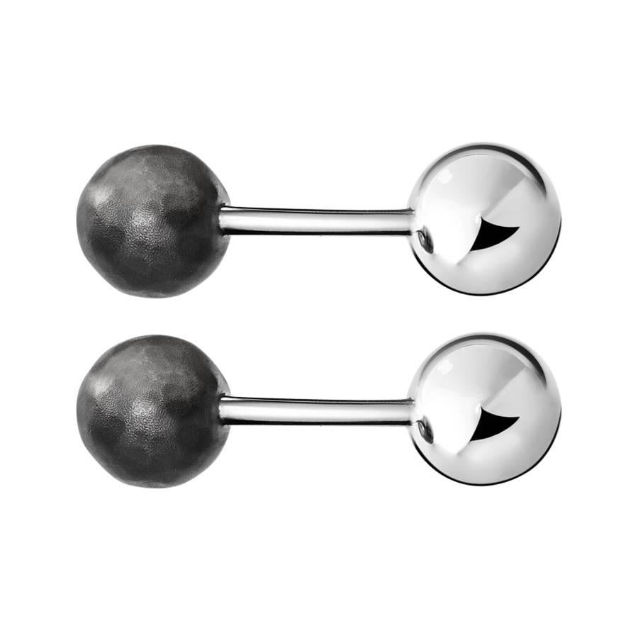 These modern cufflinks are made from 18k white gold with two spheres of steel and hammered blackend palladium. 