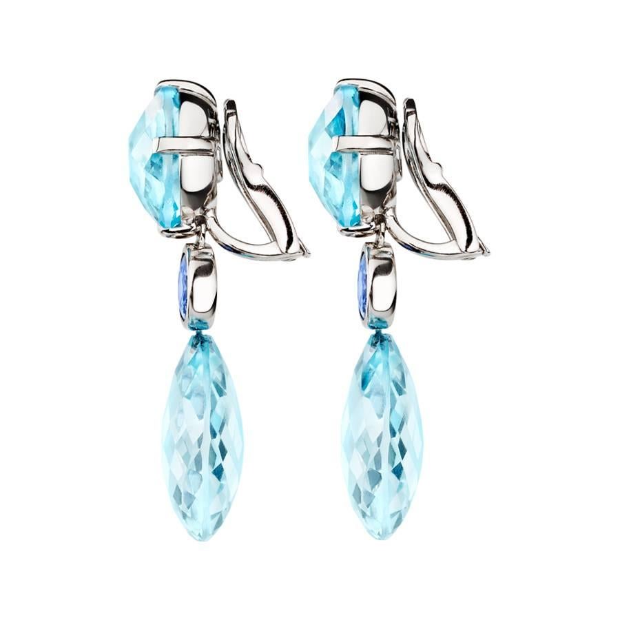These unique drop earrings feature facetted topaz gemstones and sapphires in enchanting shades of blue. The earrings are crafted in 18 karat white gold and are available in yellow gold, rose gold and platinum upon request. The earrings have a