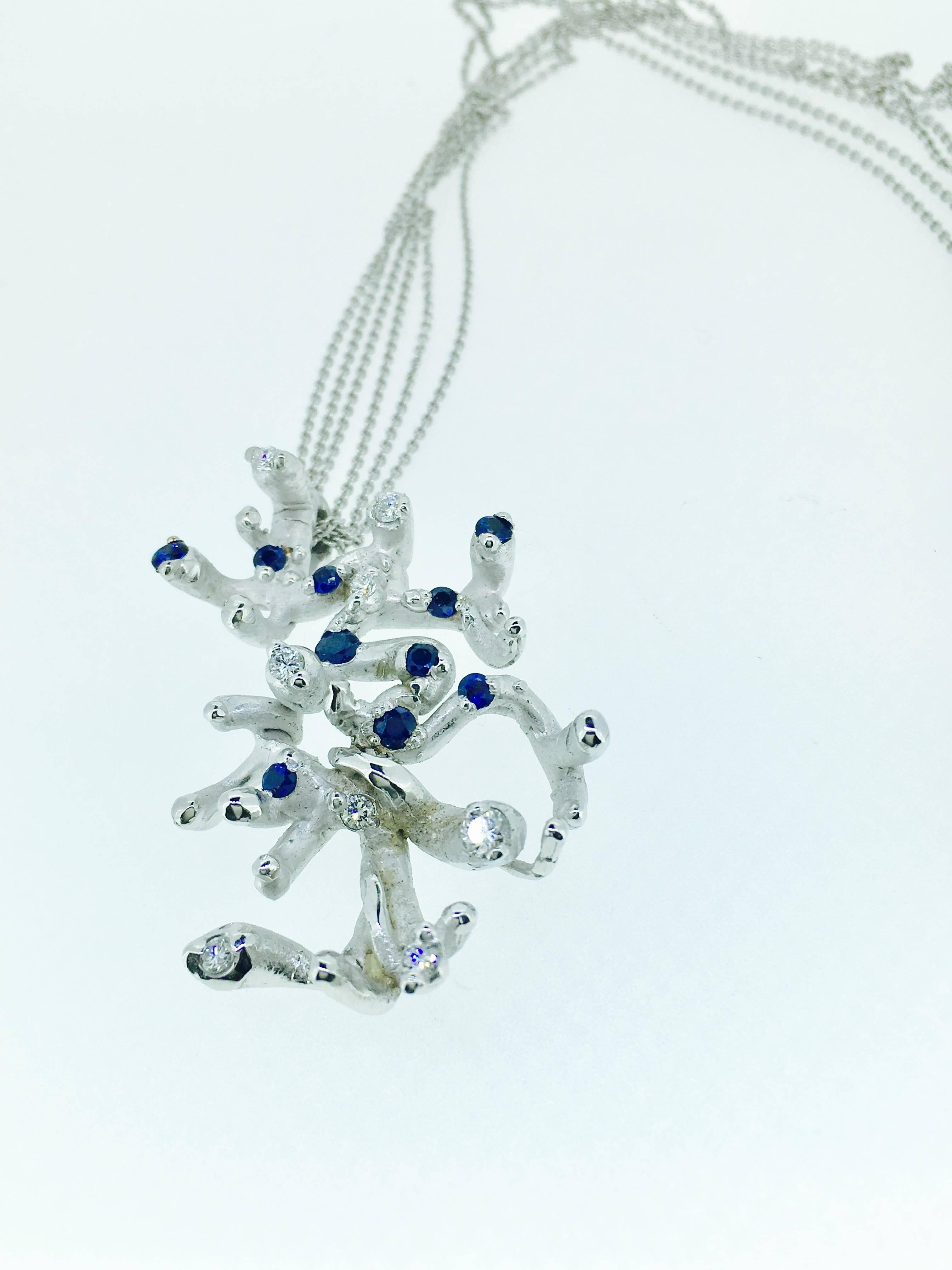 This one of a kind Necklace is a mini Sculpture-like Modernist piece signed SVG.
It consist of 8 Brilliants  of 0.15 Ct.
                   10 Saphires of 0.25 Ct.
It's a total of 11.7 gr White Gold .
