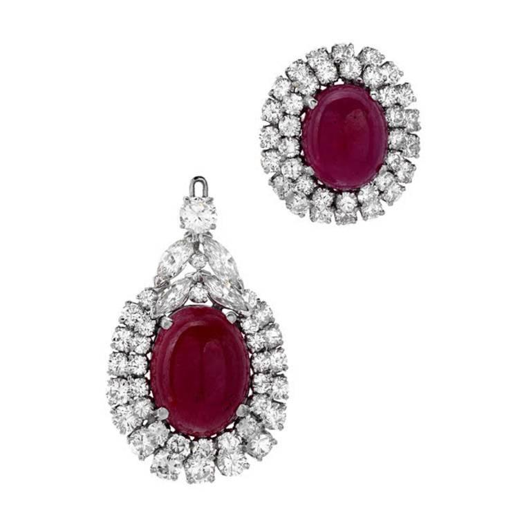 This extravagantly bold pair of earrings are not for the faint of heart! 46.30 carats of deep red cabochon rubies take center stage in these detachable drop earrings. The 18.80 carats of round and marquise cut white VS quality diamonds hold their