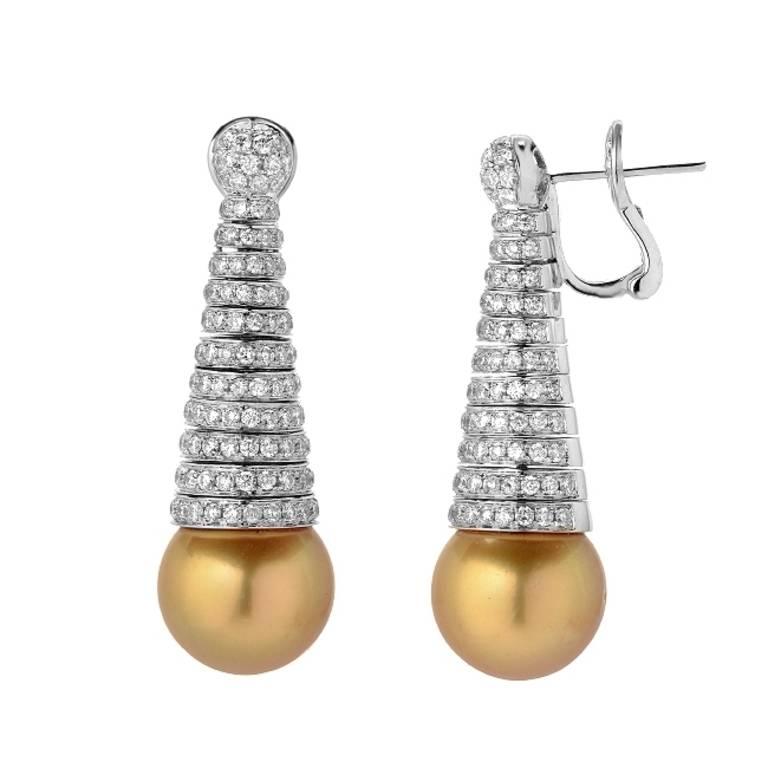 This pair of drop earrings features two matching round 13mm golden South Sea pearls. The 3.21 carats of round cut colorless VS quality diamonds are spiraled into a cone shape in an 18K white gold setting. The omega clip backing ensures for a
