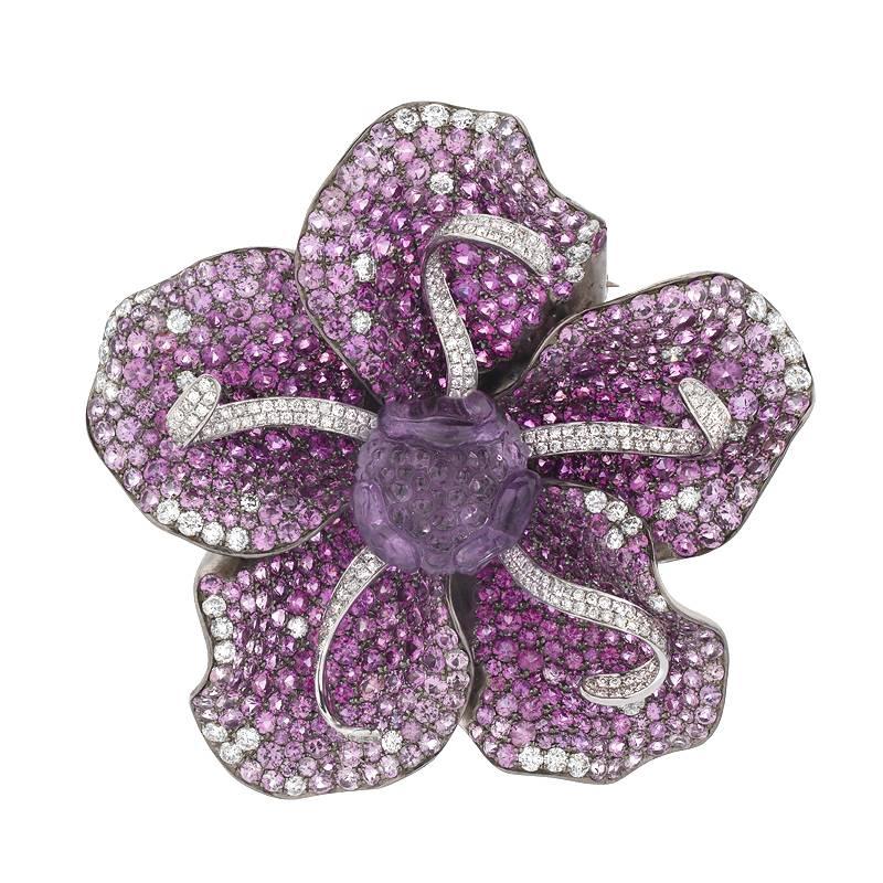 This unique piece can be worn three ways, as a ring, pendant and brooch. The ring shank slides on and off the bottom to easily change from ring to brooch and back. It features 4.06 carats of diamond, 16.17 carats of pink and purple sapphire, and a