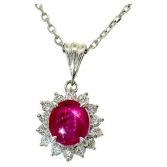 Collana con ciondolo a forma di stella in rubino, diamanti e platino con effetto halo