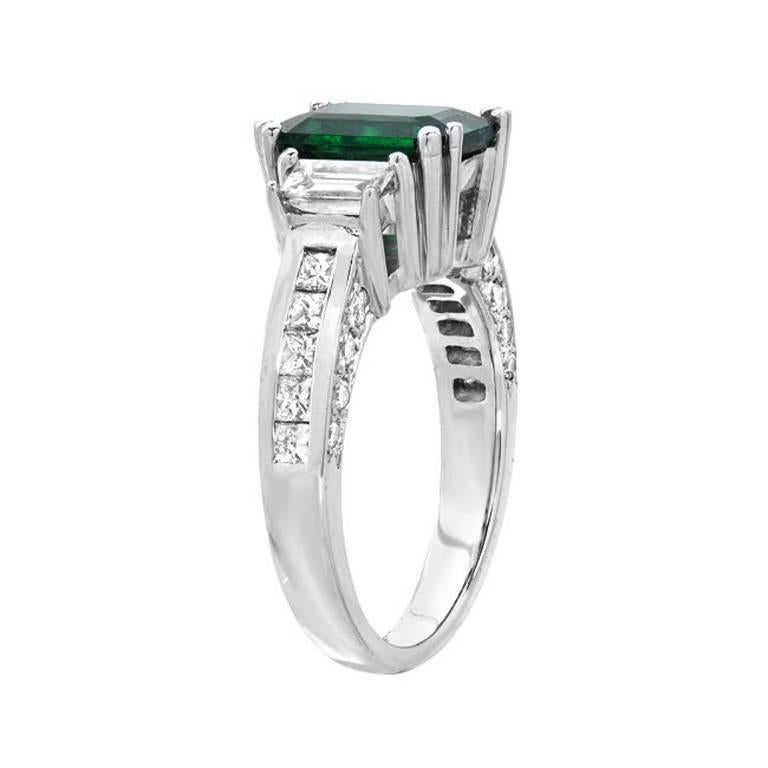 This fine deep green 2.32 carat emerald is accompanied by two baguette cut diamonds as well as full-cut diamond accents on the sides of the ring, weighing 1.33 carats. Set in 18K gold.

