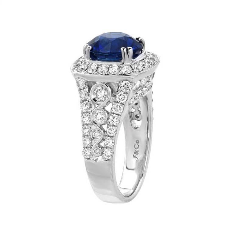 This special ring features 4.15 carat round shape blue sapphire with top gem quality vivid blue color. A prime example of a high-quality sapphire. It is haloed by 1.86 carats of sparkling round cut diamonds set in 18K white gold. This is a ring for