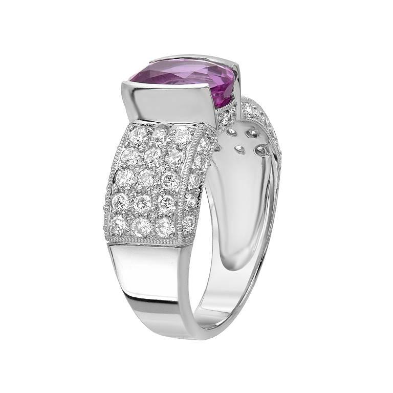 A deep colored 3.08 carat oval shape pink sapphire with 1.01 carats of full-cut diamonds, set in 18K gold. 

